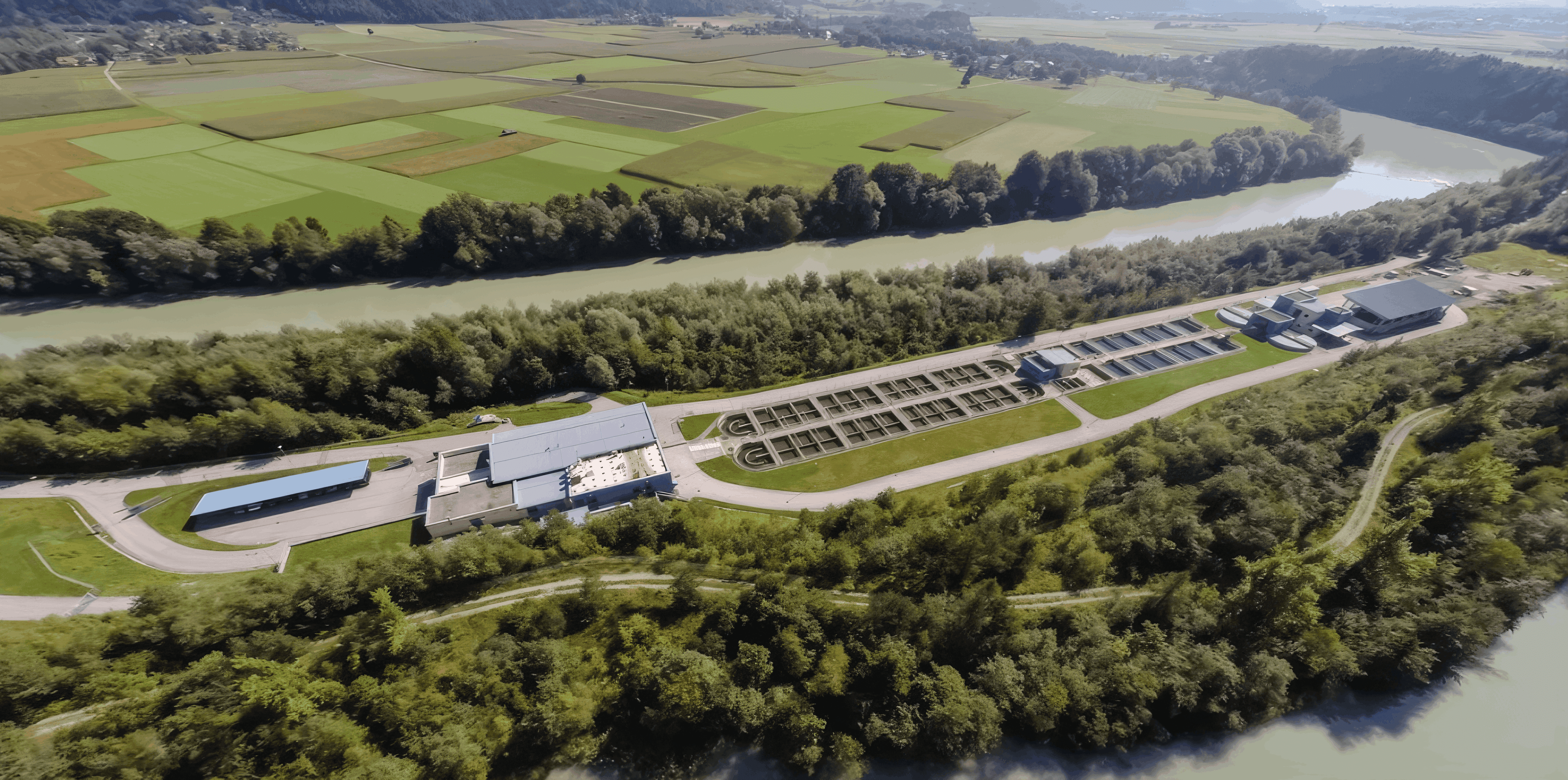 MW Interior - Luftaufnahme eines Wasserwerks mit Klärbecken an einem Fluss umgeben von Feldern und Wäldern" Beschreibung: Luftaufnahme eines Wasserwerk-Standorts – ein Referenzprojekt, bei dem auch in technischen Betriebsgebäuden hochwertige Inneneinrichtungslösungen realisiert wurden.