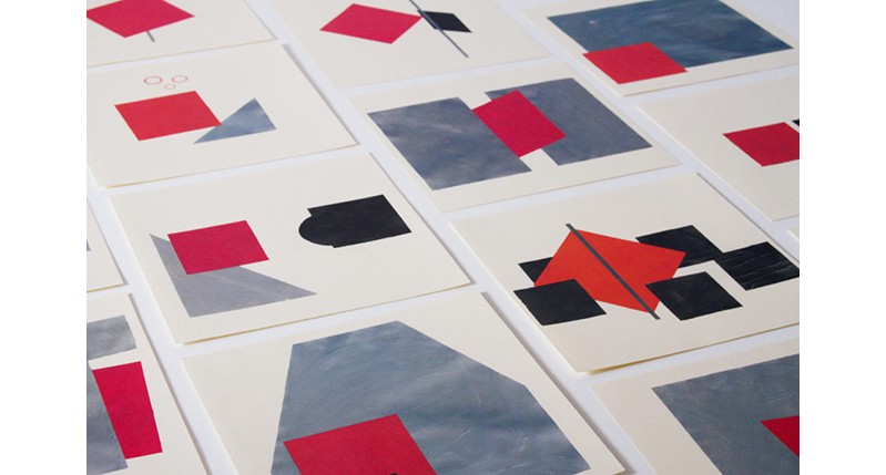 A set of white cards with grey, black and white shapes on them.