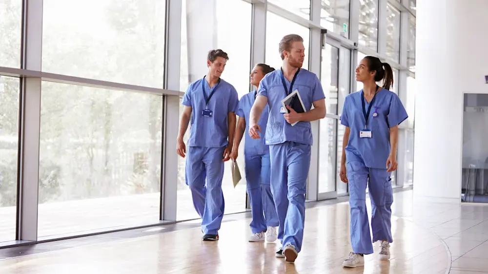 doctors in scrubs walking down hallway
