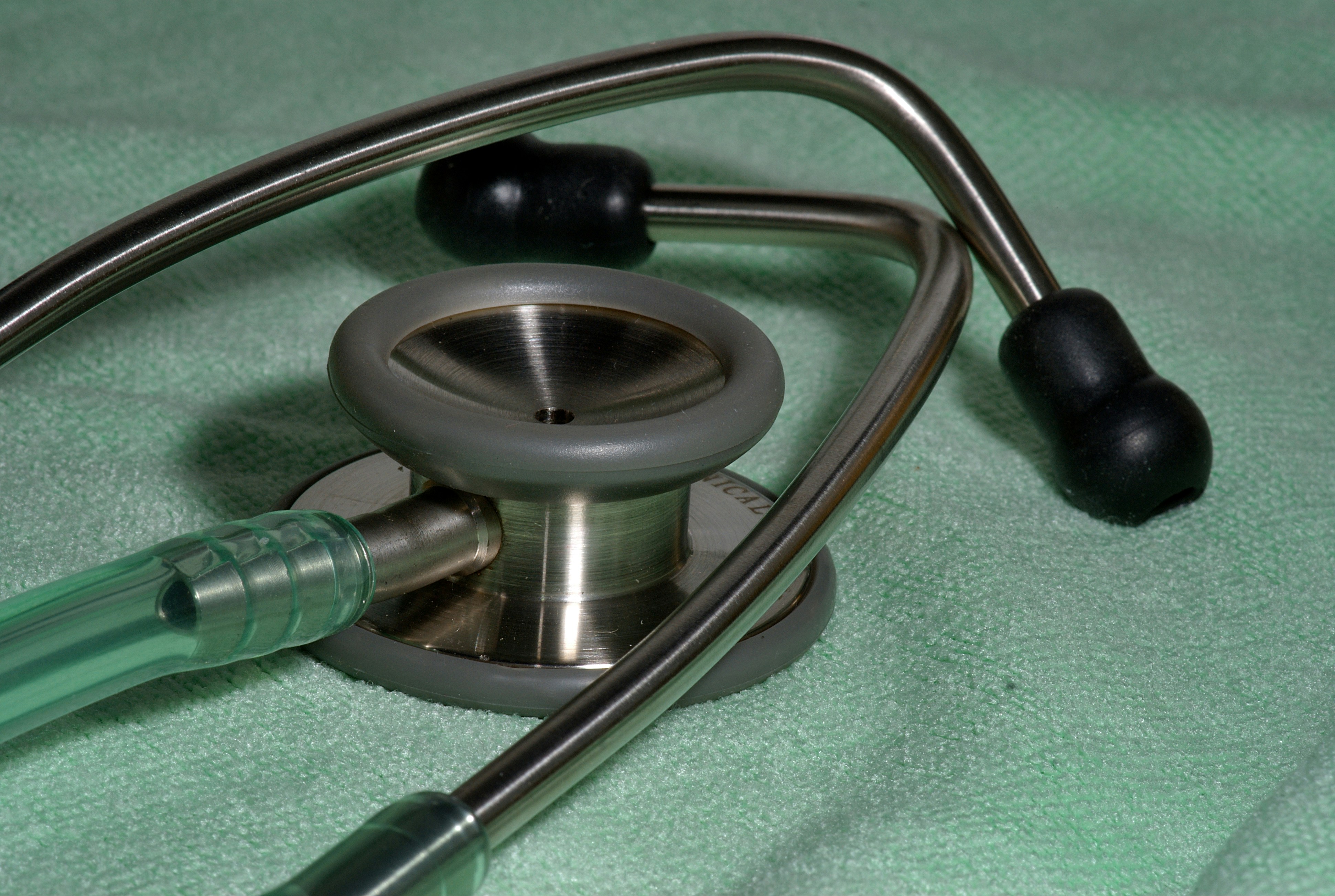 a stethoscope laying on top of a green blanket