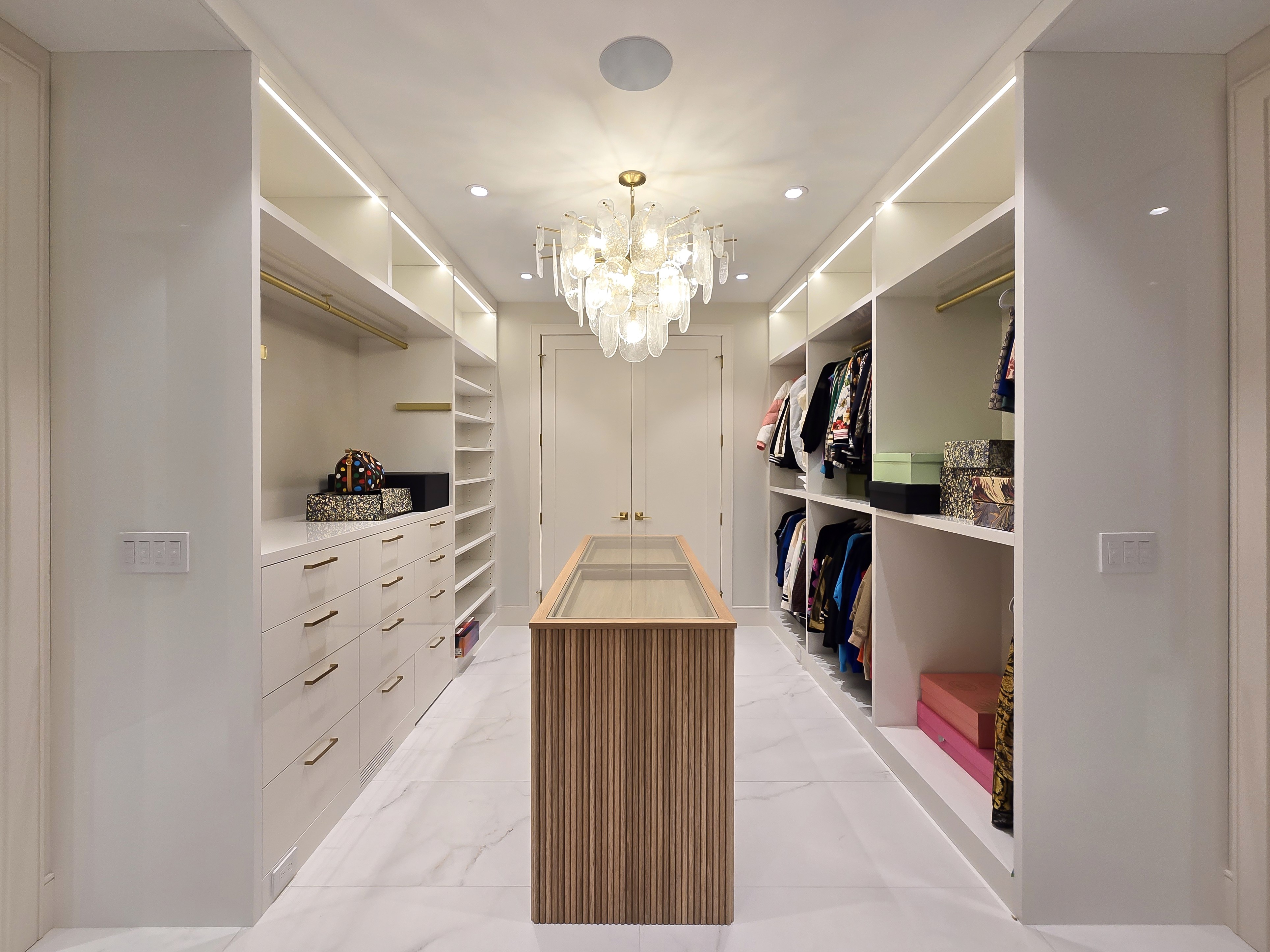 Image of Luxurious walk-in closet interior with custom storage, furniture, and lighting, showcasing KHD Homes design-build expertise.