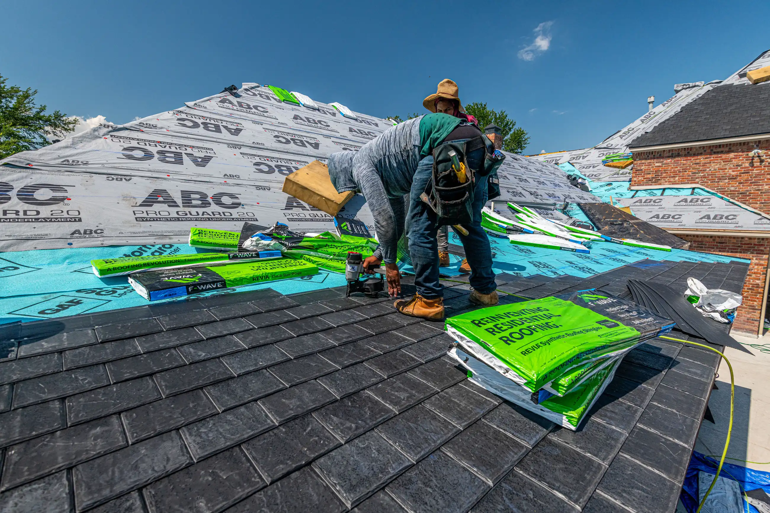 Roofer installing shingles on a pitched roof