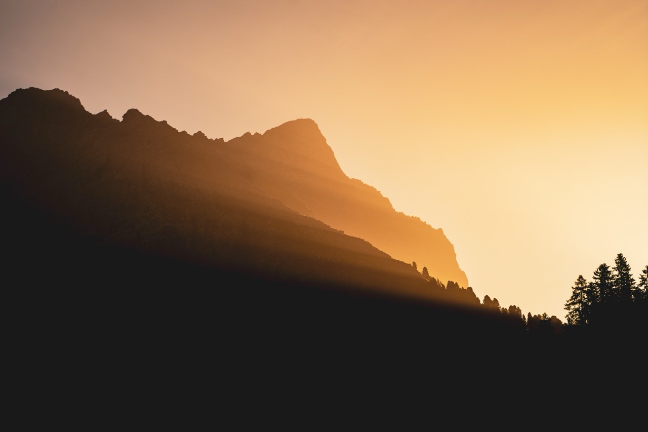 Ruhige Berglandschaft über einem See im warmen Morgenlicht