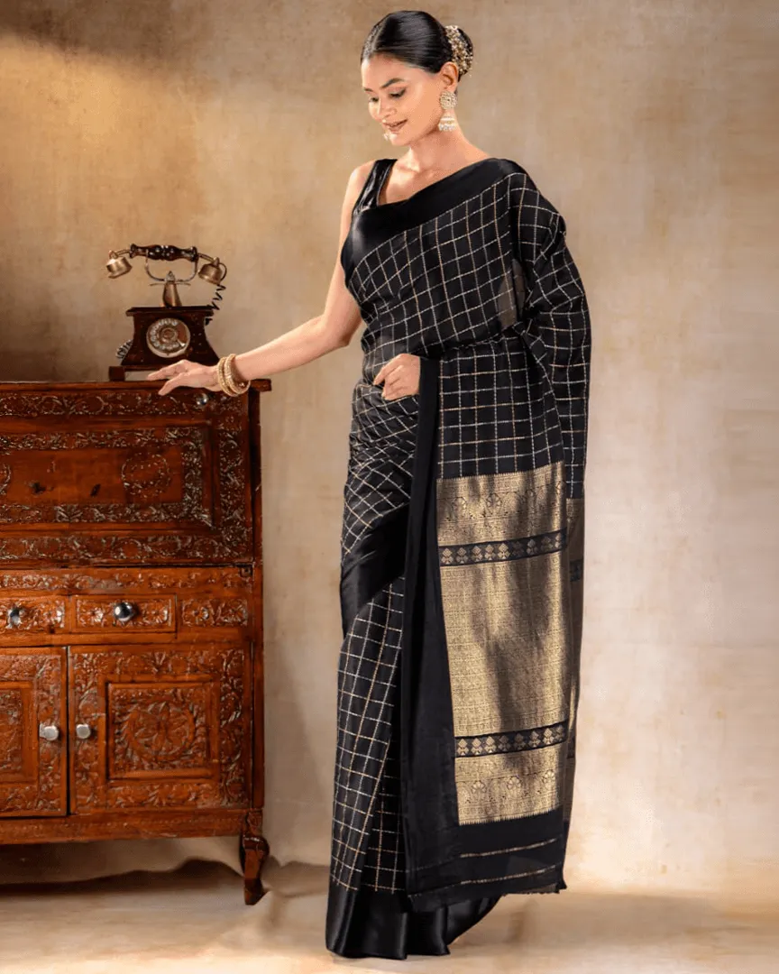 A woman wearing a black crepe saree with delicate golden borders from That Saree Shop, highlighting the saree’s fluid drape and refined craftsmanship for an elegant, modern look.