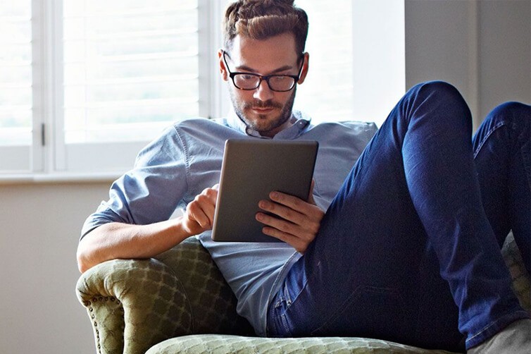 Man sitting on armchair using a tablet
