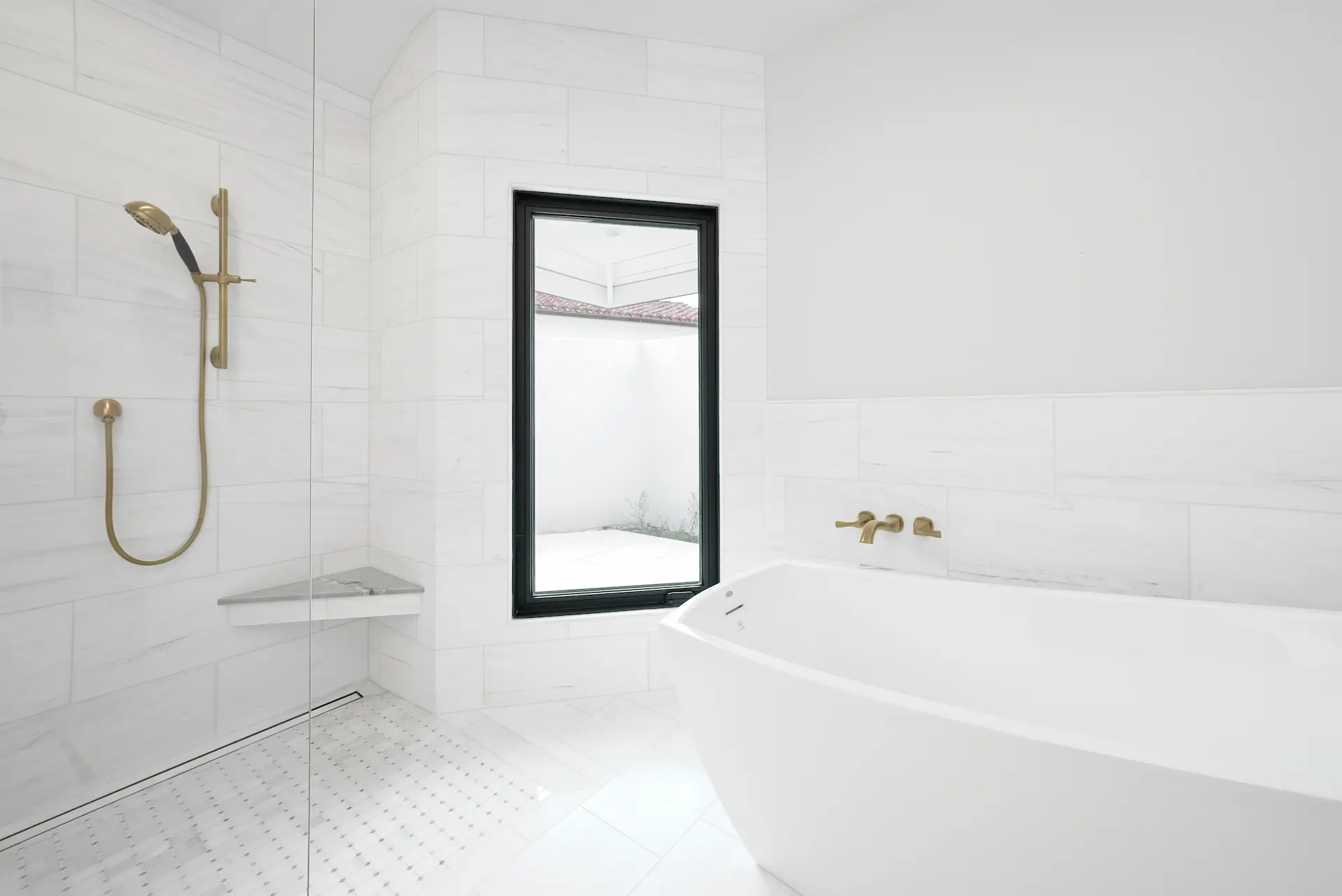 Wide view of the primary bathroom, featuring a luxurious walk-in shower and elegant free-standing tub under a skylight, embodying opulence and modern design in the Dana Point Full Remodel. Photo by Todd Huge.