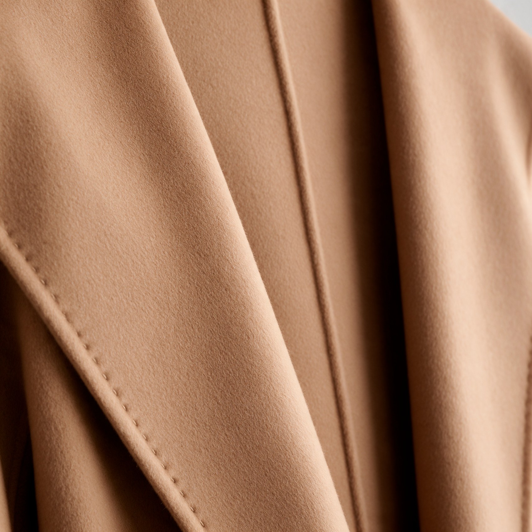 The lapel edge, closed by hand