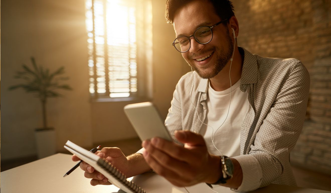 Imagem mostra homem organizando suas finanças pessoais no celular