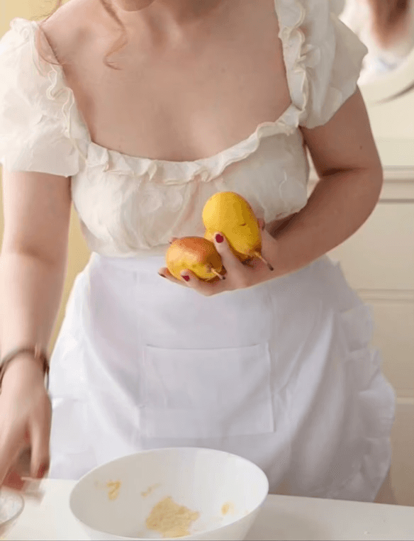 Sunlit orange armchair beside sheer curtains, wooden floor.