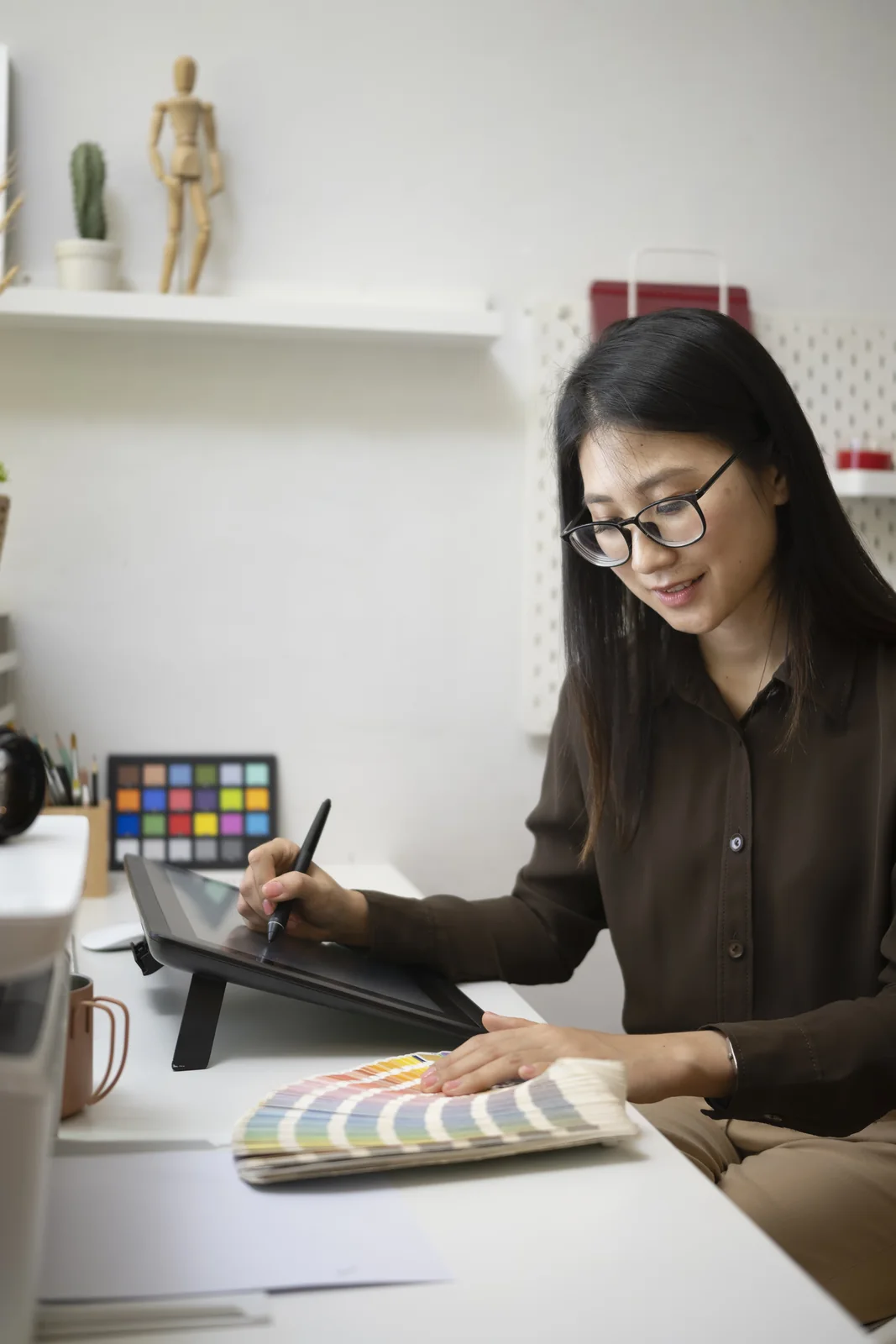 Young Woman Works on Digital Art at Desk