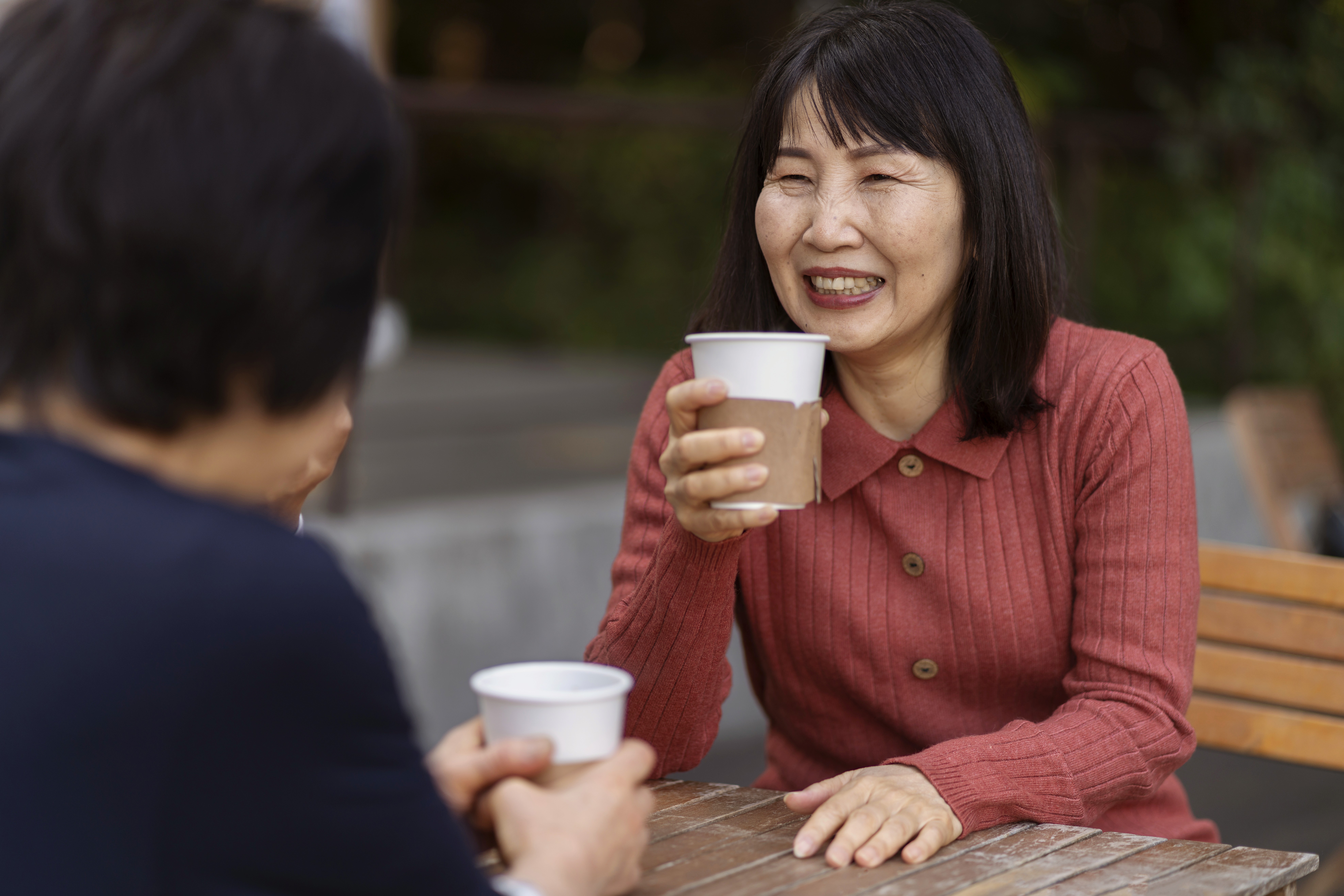 Close-up of a dark green leaf showing its textured surface and central vein against a muted background.