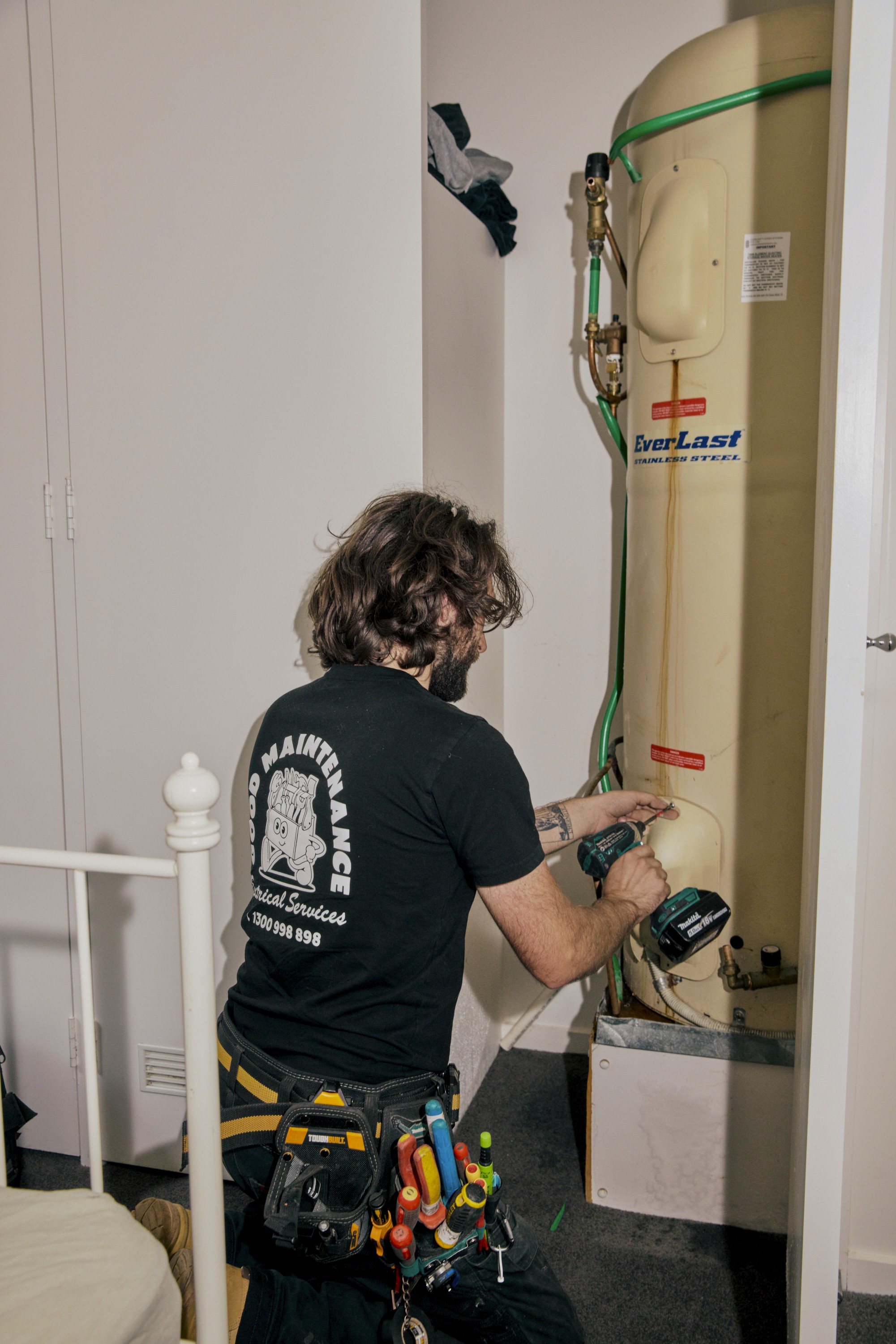 A Good Maintenance team member wearing a company shirt with graphics.