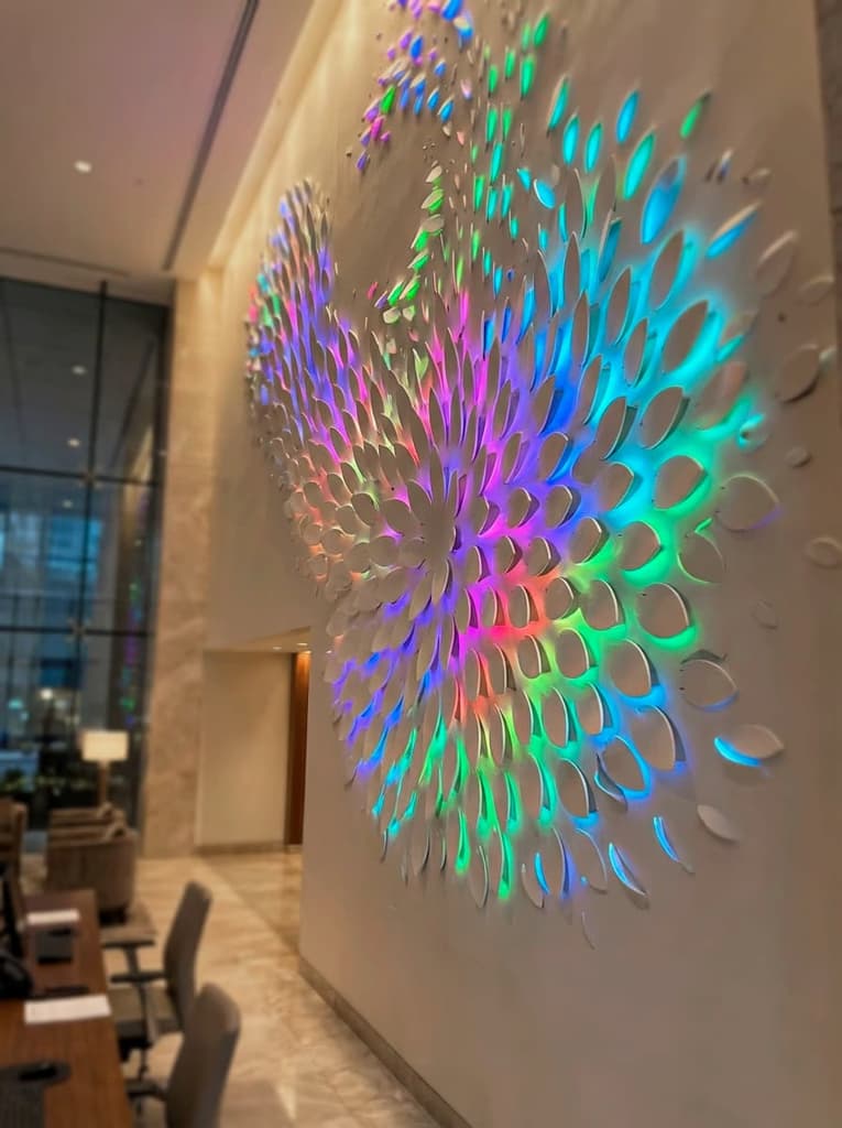 Feature wall made of leaf-like shapes that lift off the wall letting colorful RGB lighting show from underneath