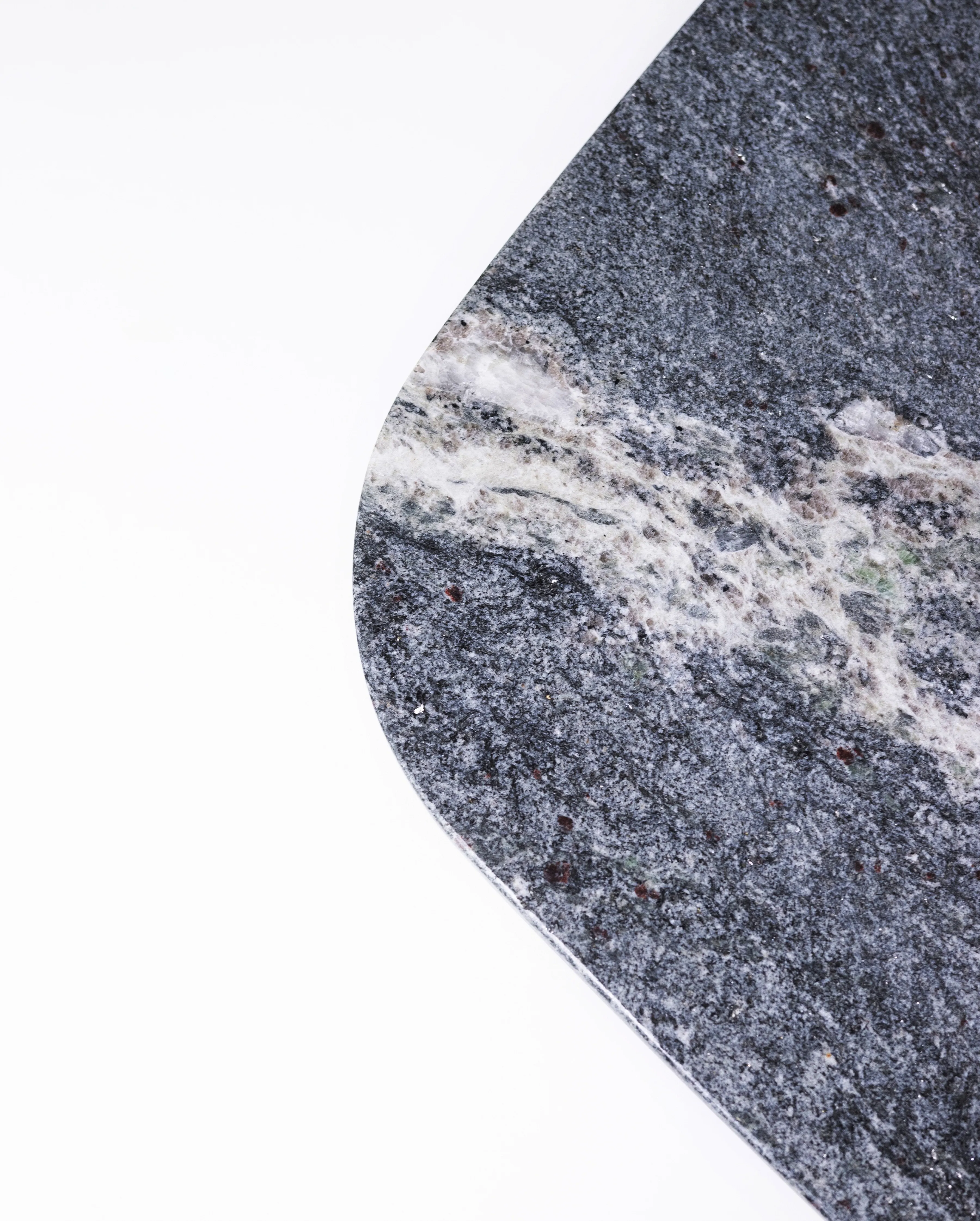 Detalle de borde redondeado en mesa de piedra gris