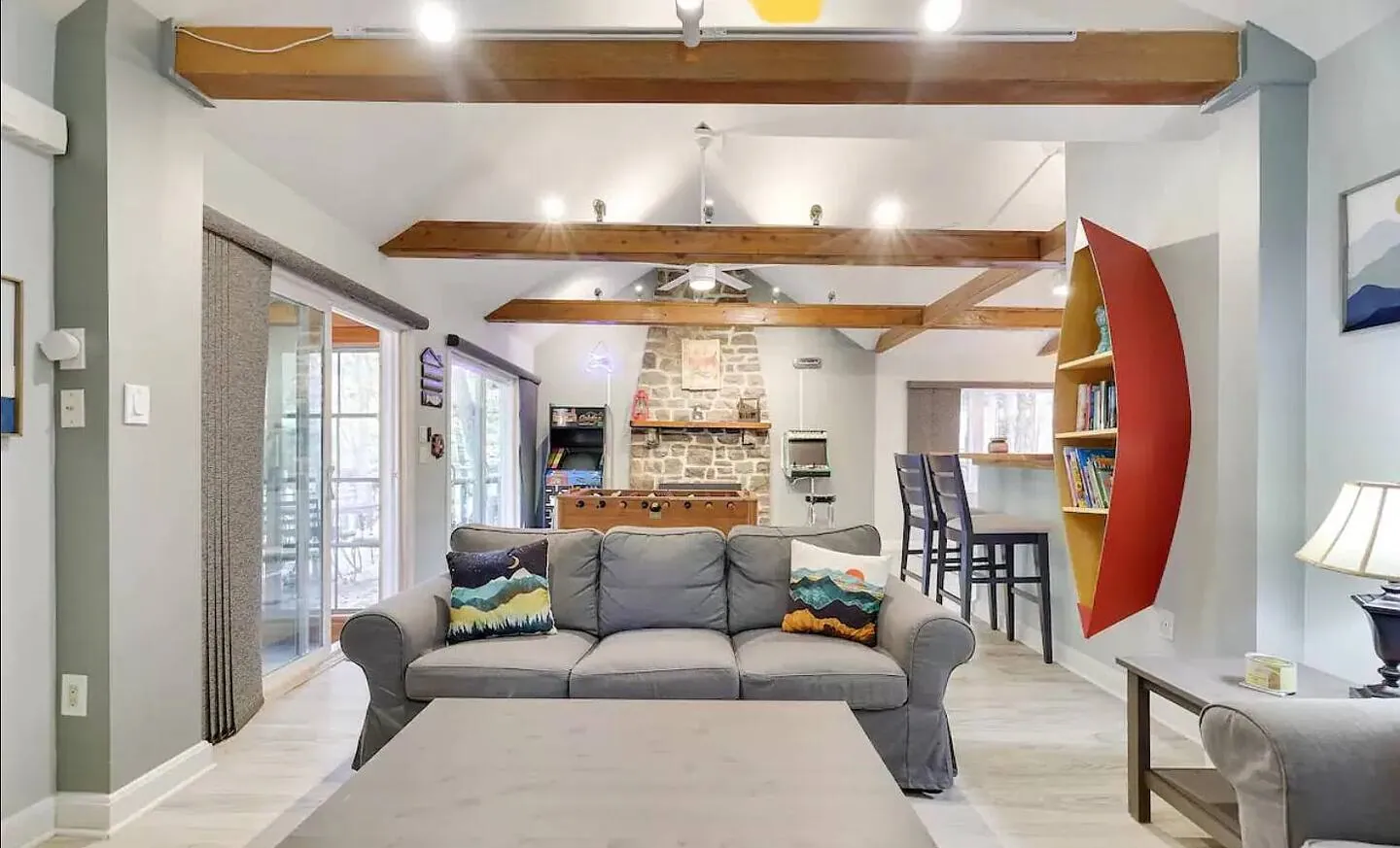 Great room with gray sofa, coffee table and stone fireplace at Barefoot Bungalow