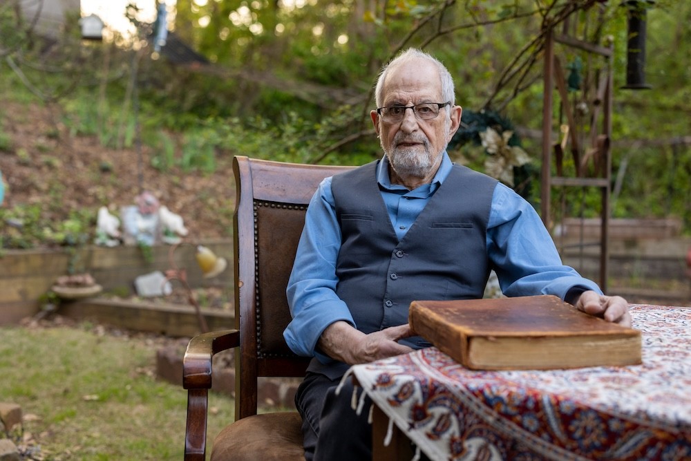 Bubjan with book and speaking to camera