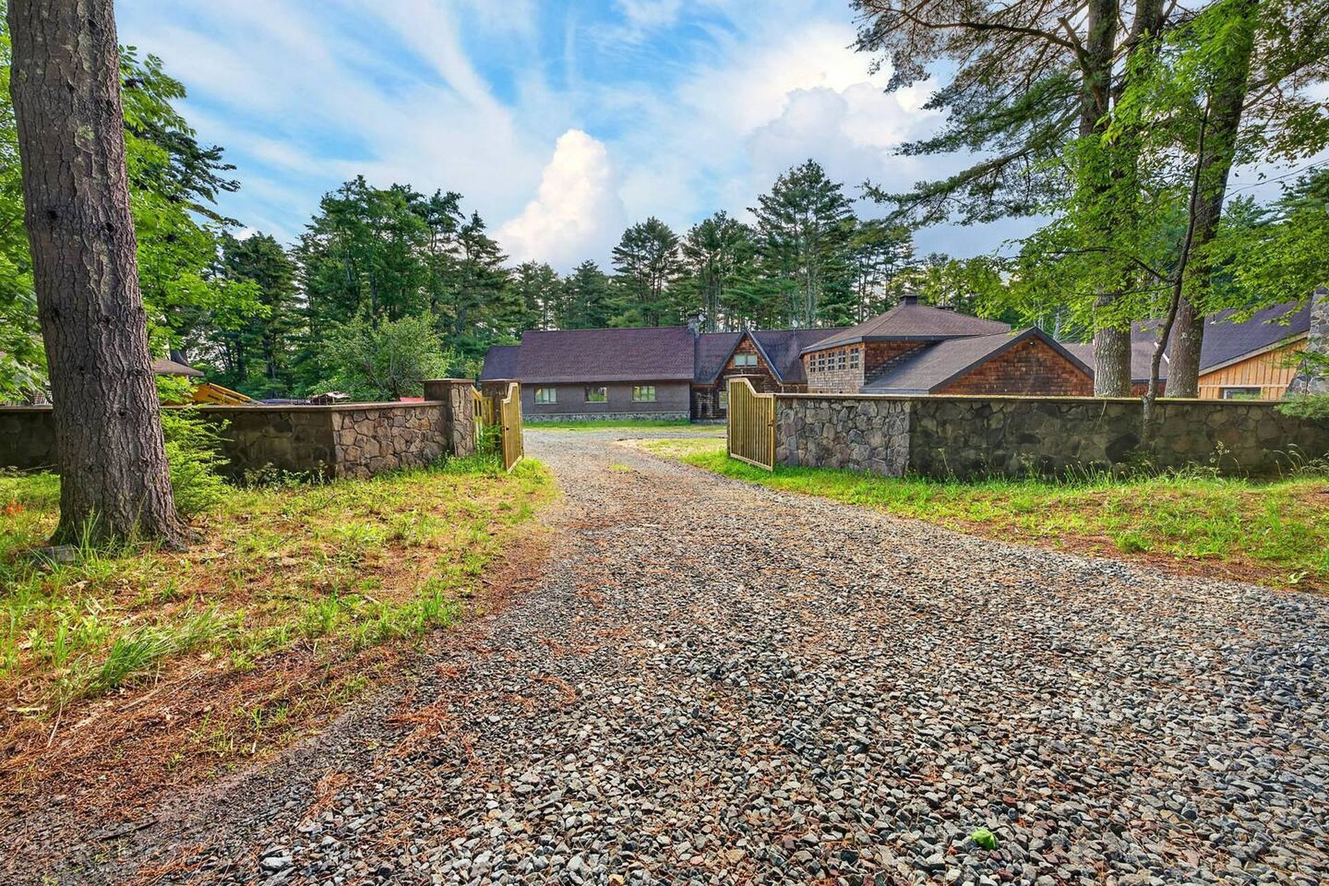 Gravel drive between fieldstone walls leading to the estate