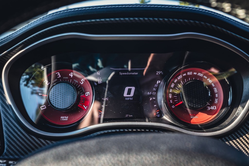 The image shows a car dashboard display with a speedometer, temperature gauge, and various numerical readings related to engine performance