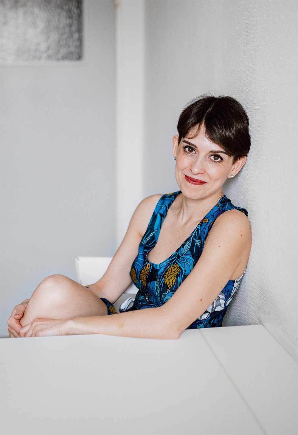 Francesca Introvaia, social media strategist, seated in a light-filled space wearing a blue patterned dress.
