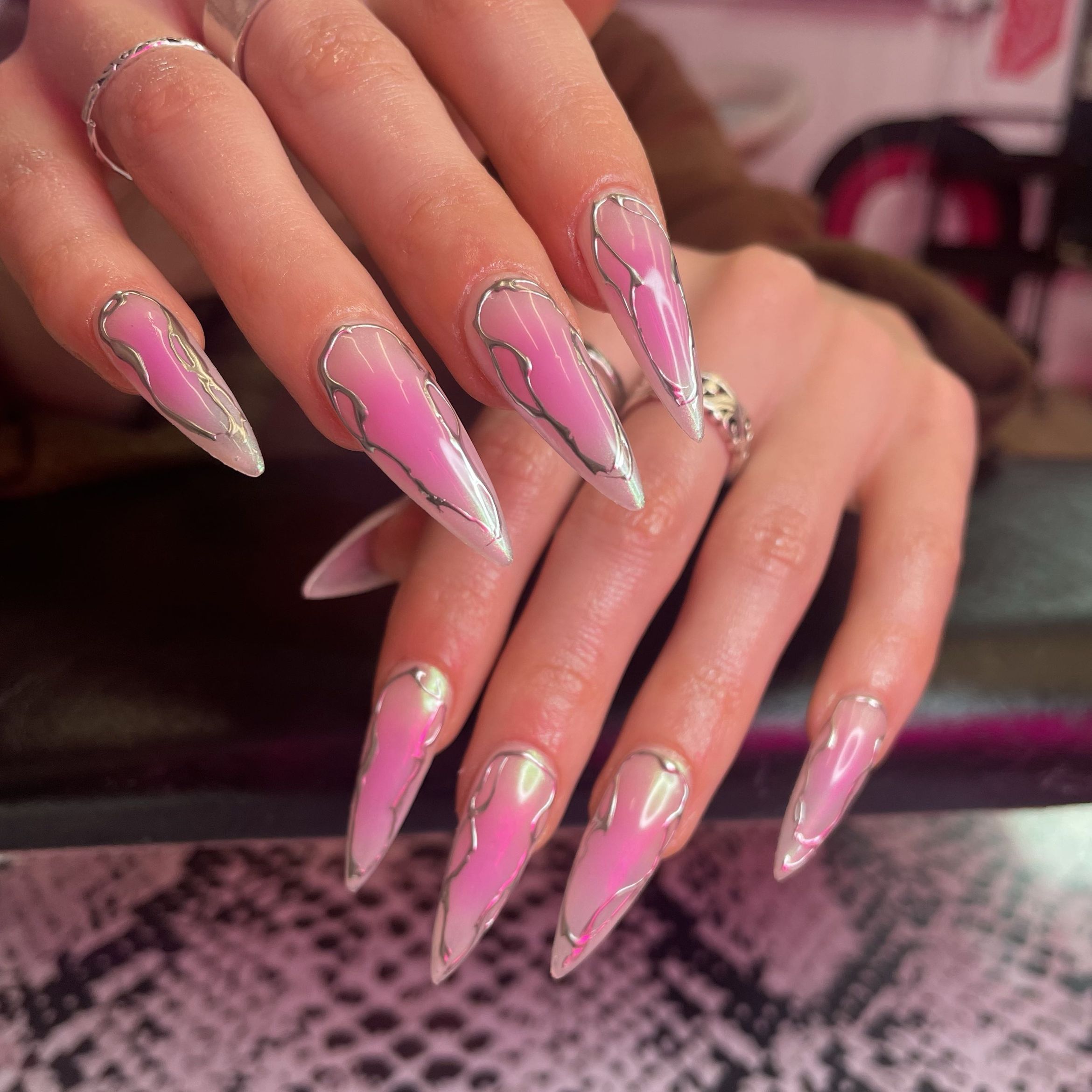 Long stiletto nails with a sheer pink-to-white ombré base, encased in 3D metallic silver "molten" lines that mimic spider webs or liquid metal.
