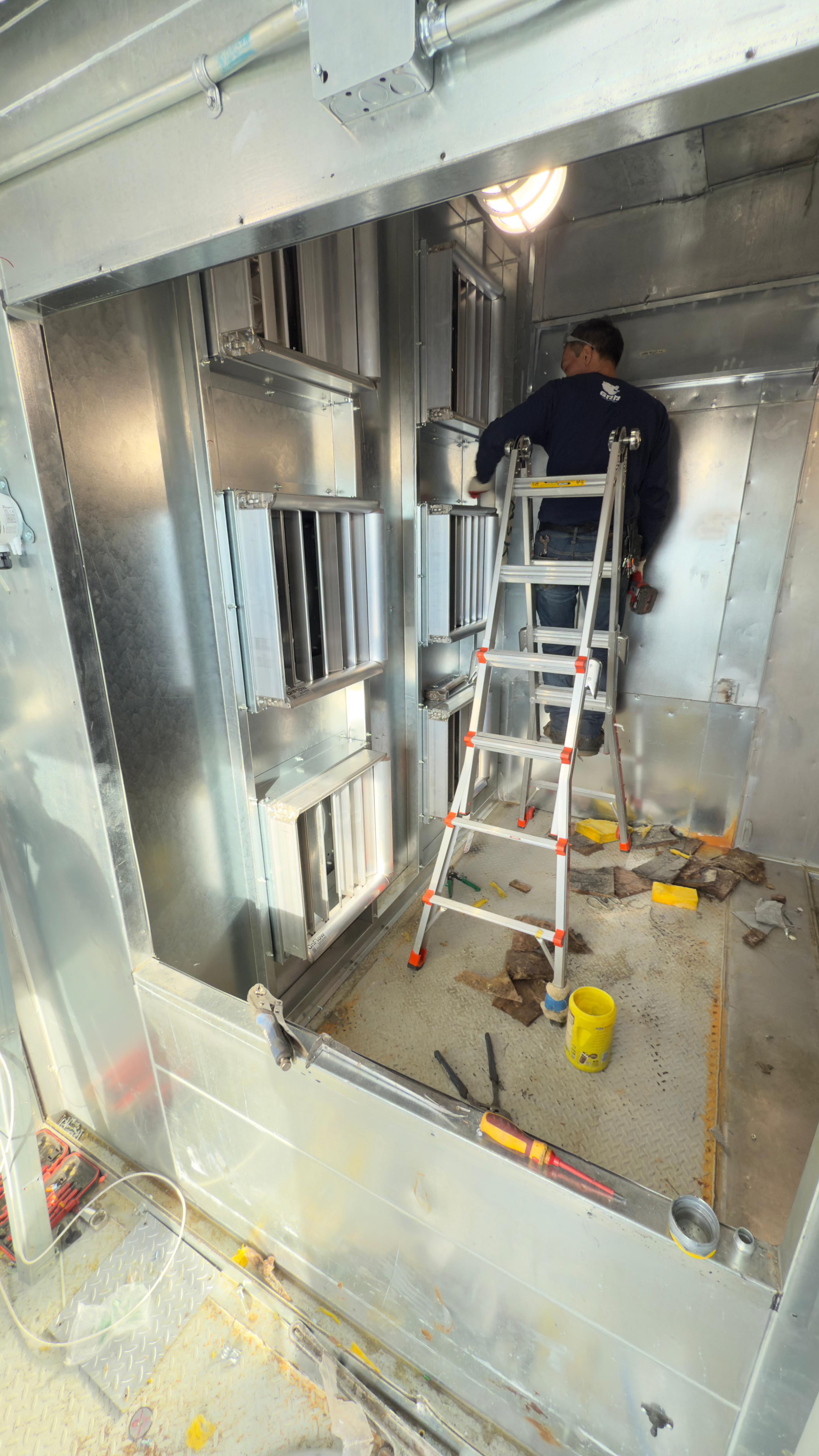 GRR Cooling Experts technician working inside a hospital air handling unit during live fan array retrofit.
