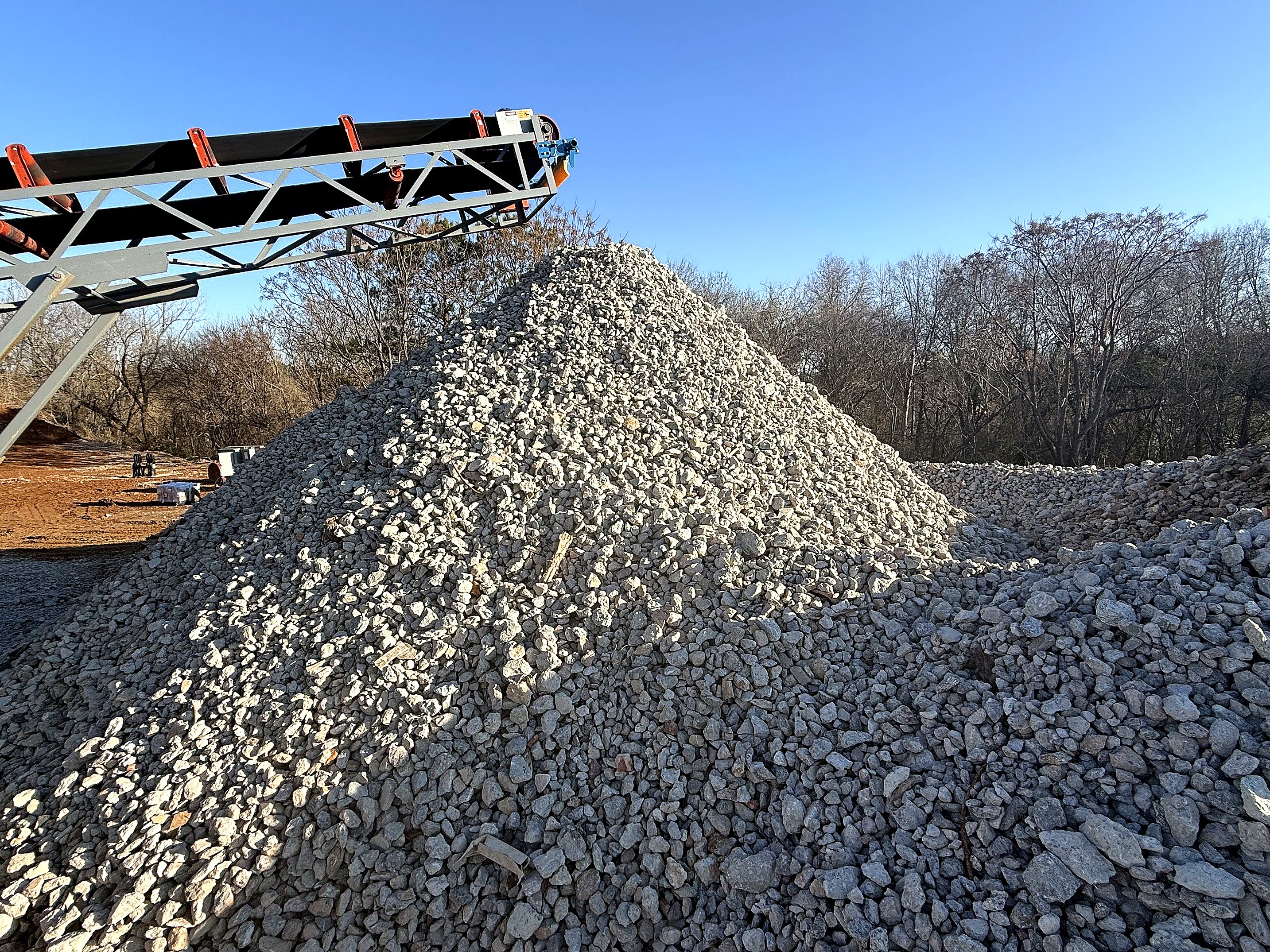 man in gray hoodie and blue denim jeans standing on brown wooden parquet flooring