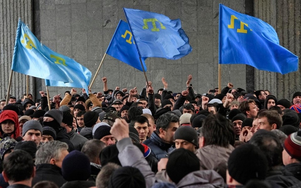 Pictured: Crimean Tatars protesting and waving their ethnic flag.