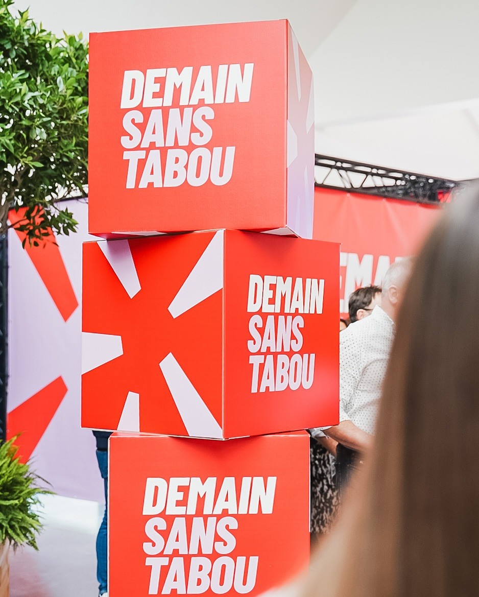 Modern home office setup with a monitor, ergonomic chair, keyboard, and indoor plants near a window with blinds.