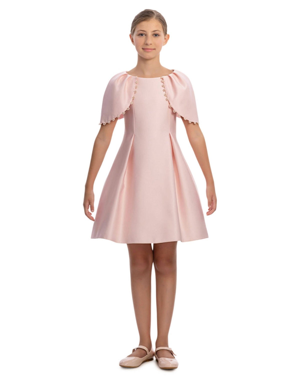 Young girl wearing a pink dress with ruffled sleeves on a white background