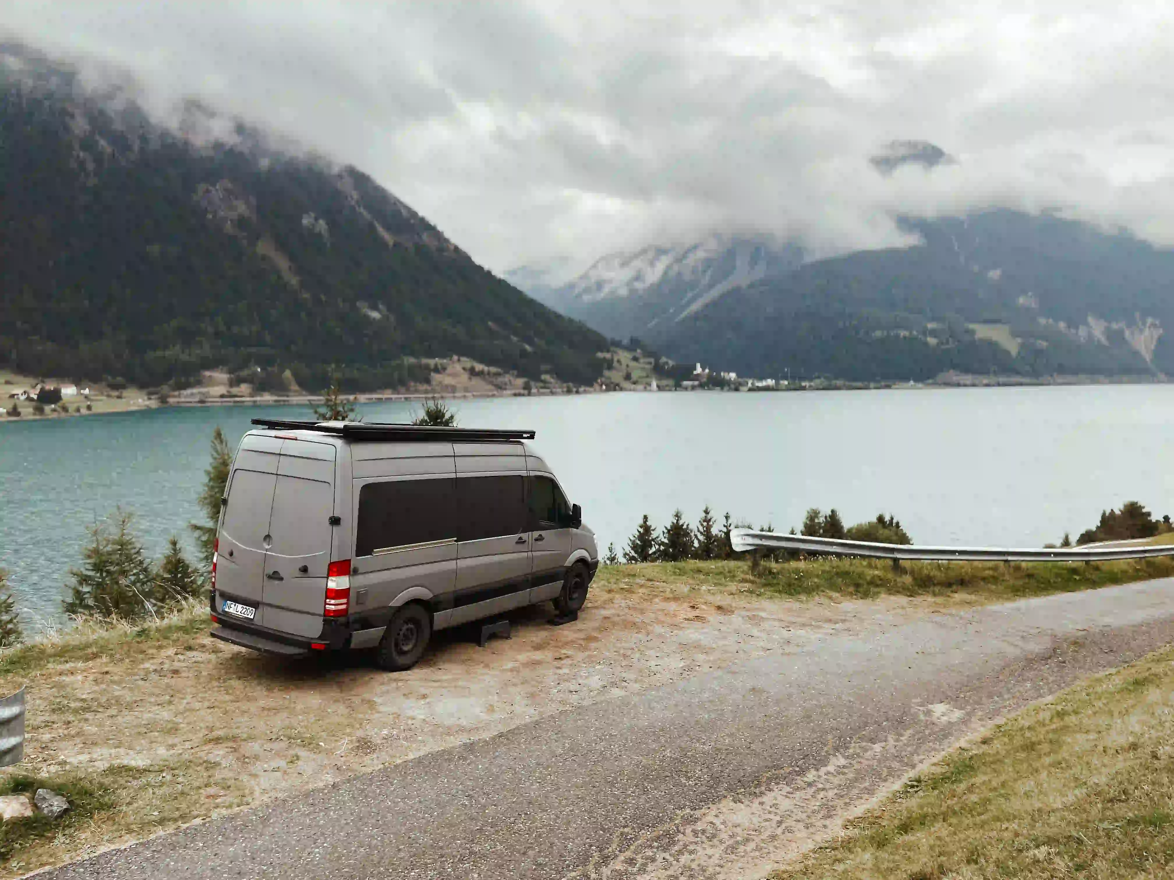 Ein Camper der vor einem see geparckt ist