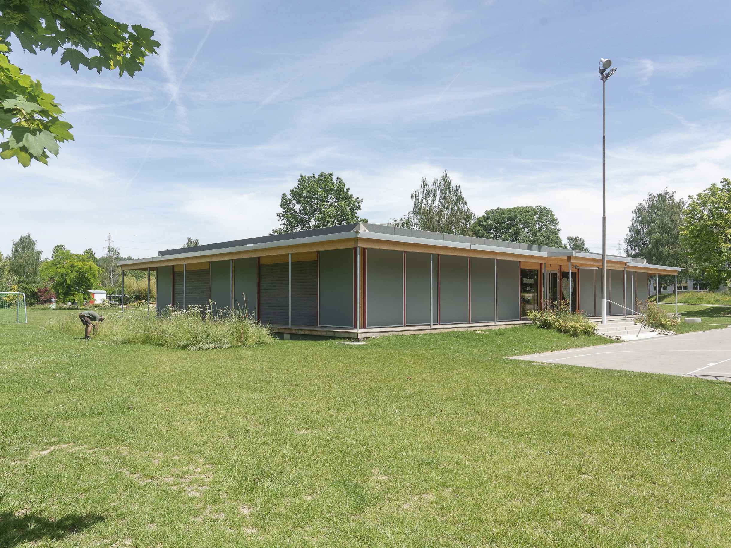 Photo architecturale d'une école enfantine dans le villge d'Échallens entourée par des massifs végétaux réalisés par Mirco Mancini