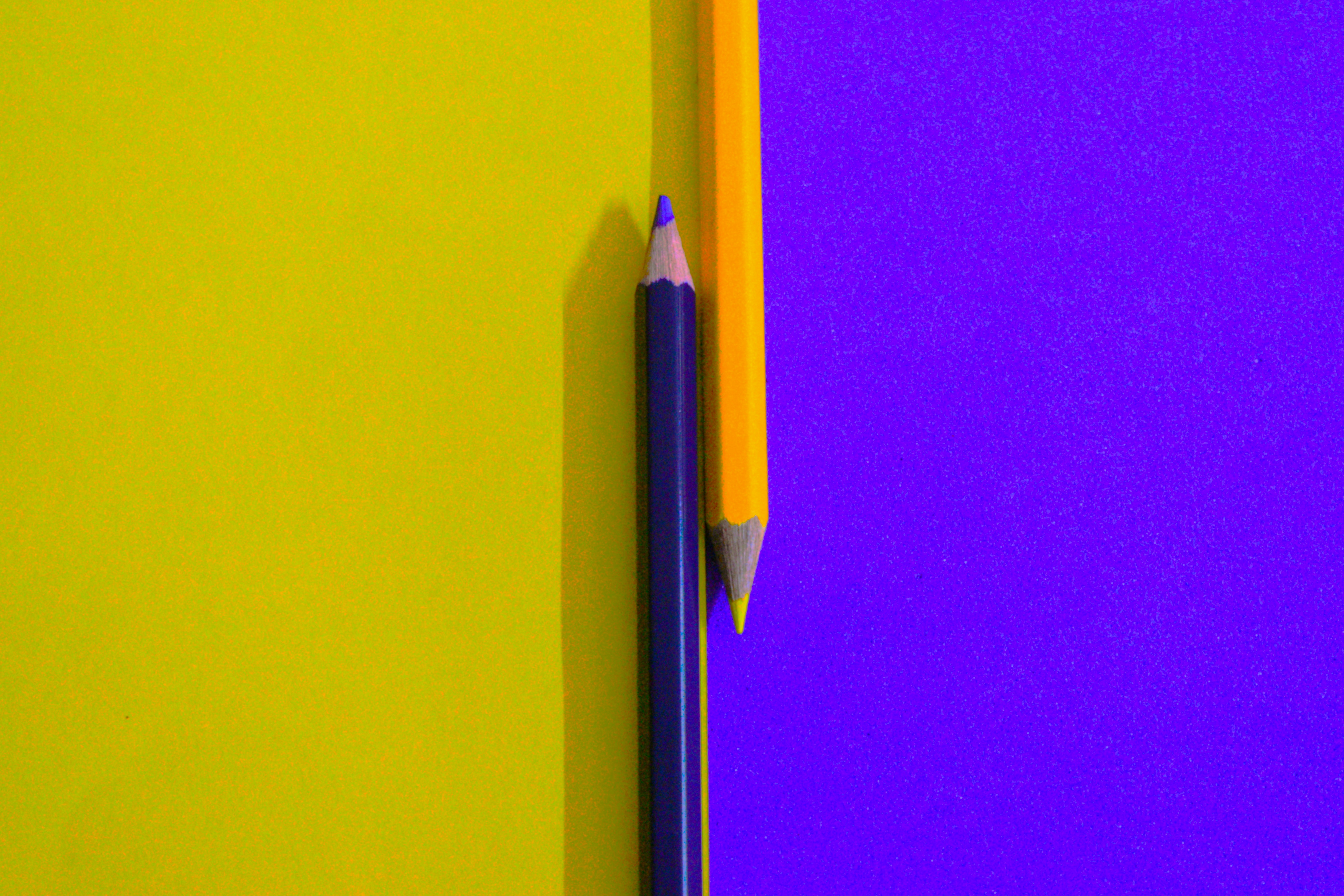 Two pencils on a bright yellow and purple background representing structured evaluation criteria
