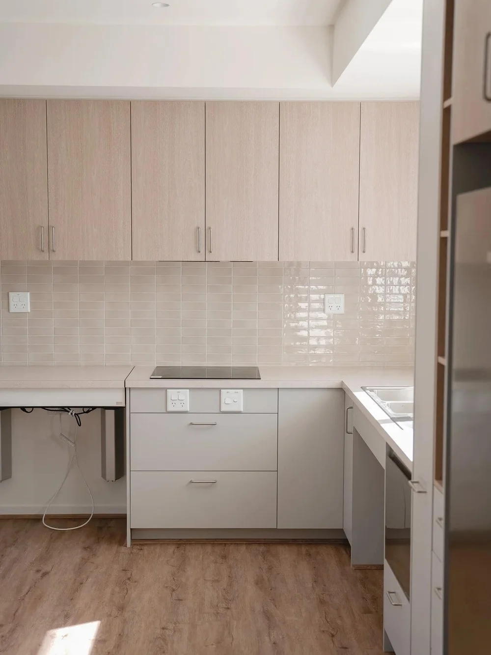 Modern kitchen design with light wood cabinets, tiled backsplash, and sleek appliances.