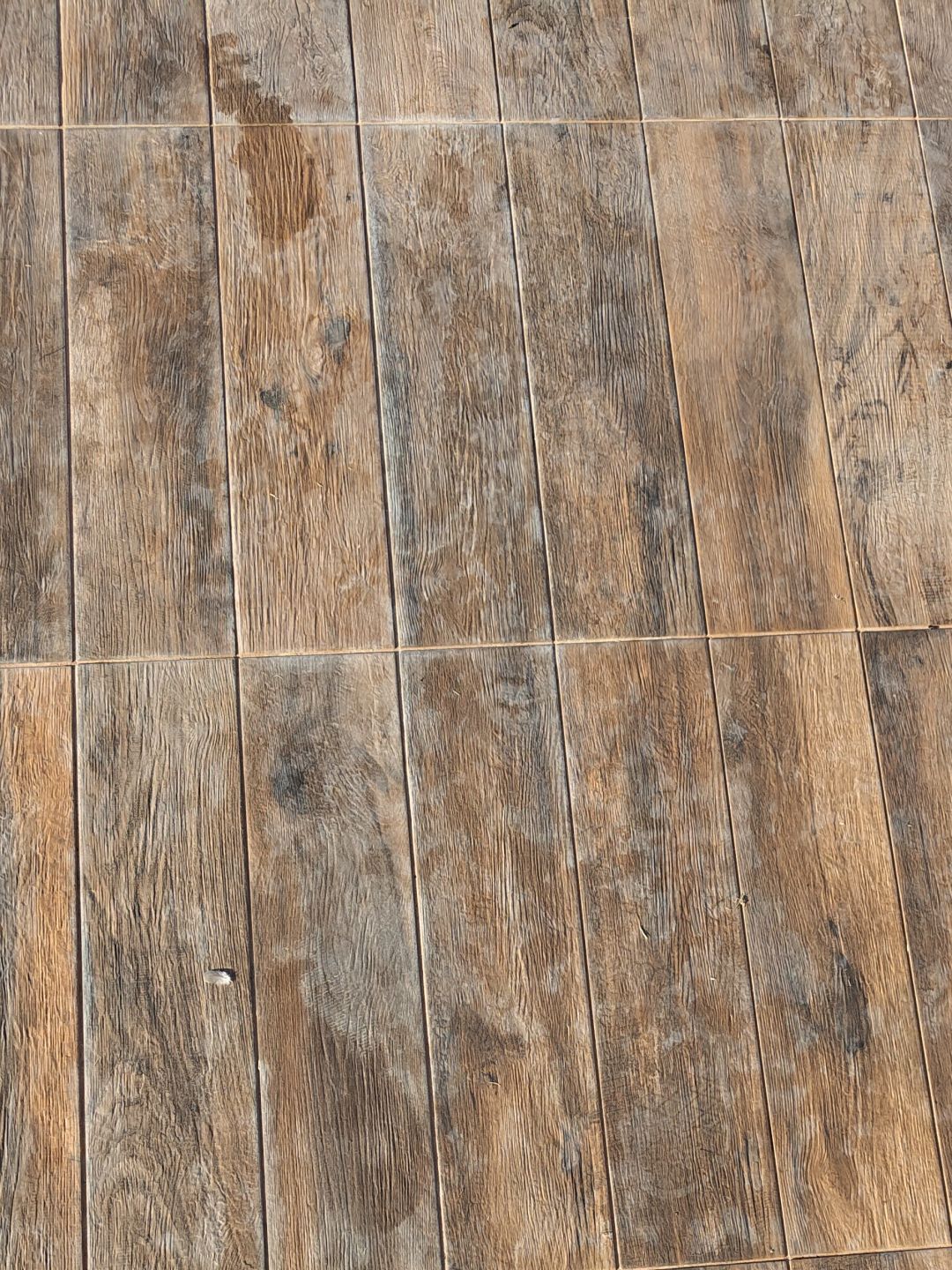 Wood-effect tiles by the pool, before treatment