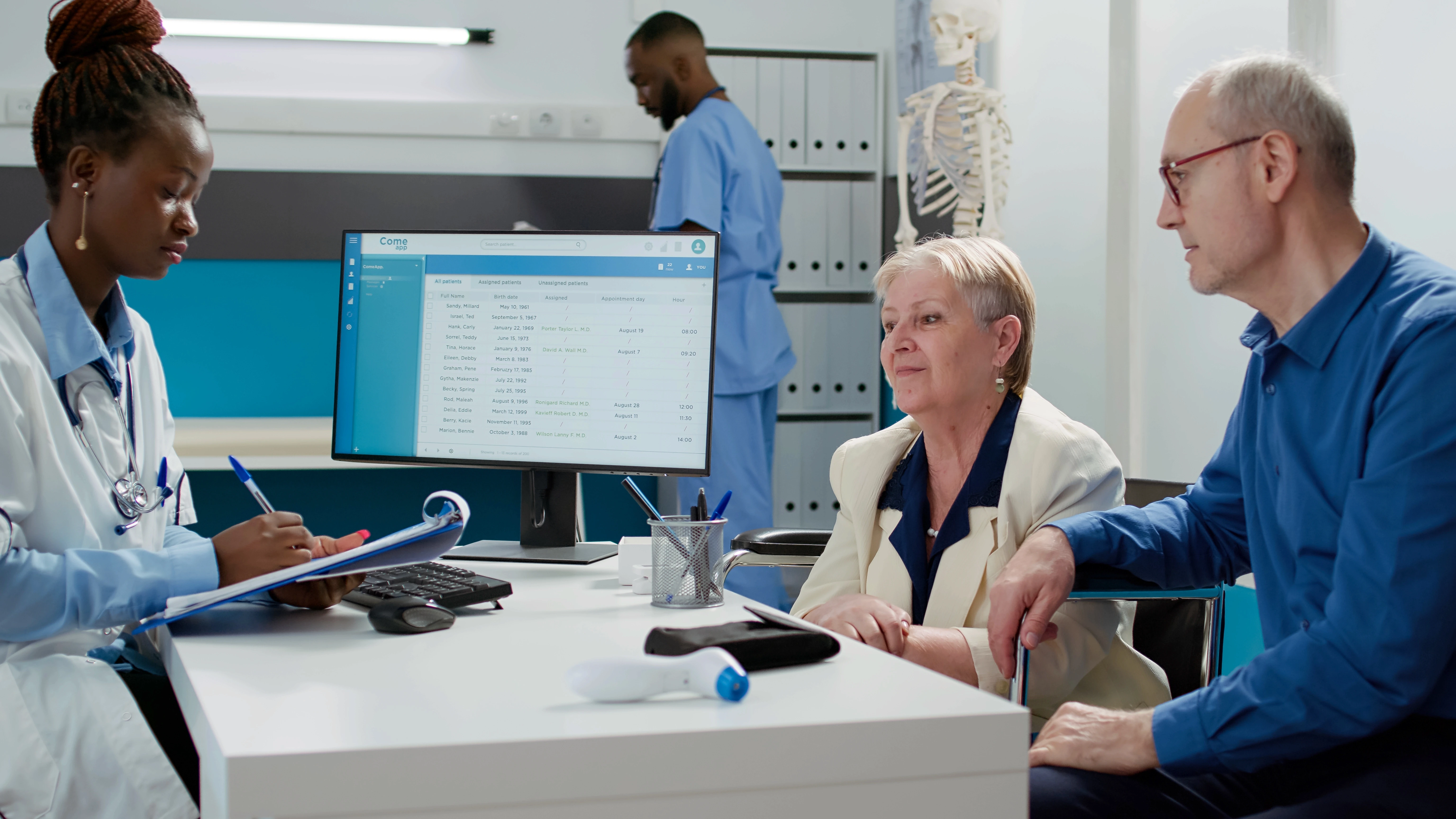 A doctor consults an elderly wheelchair-bound patient and her companion in clinic setting