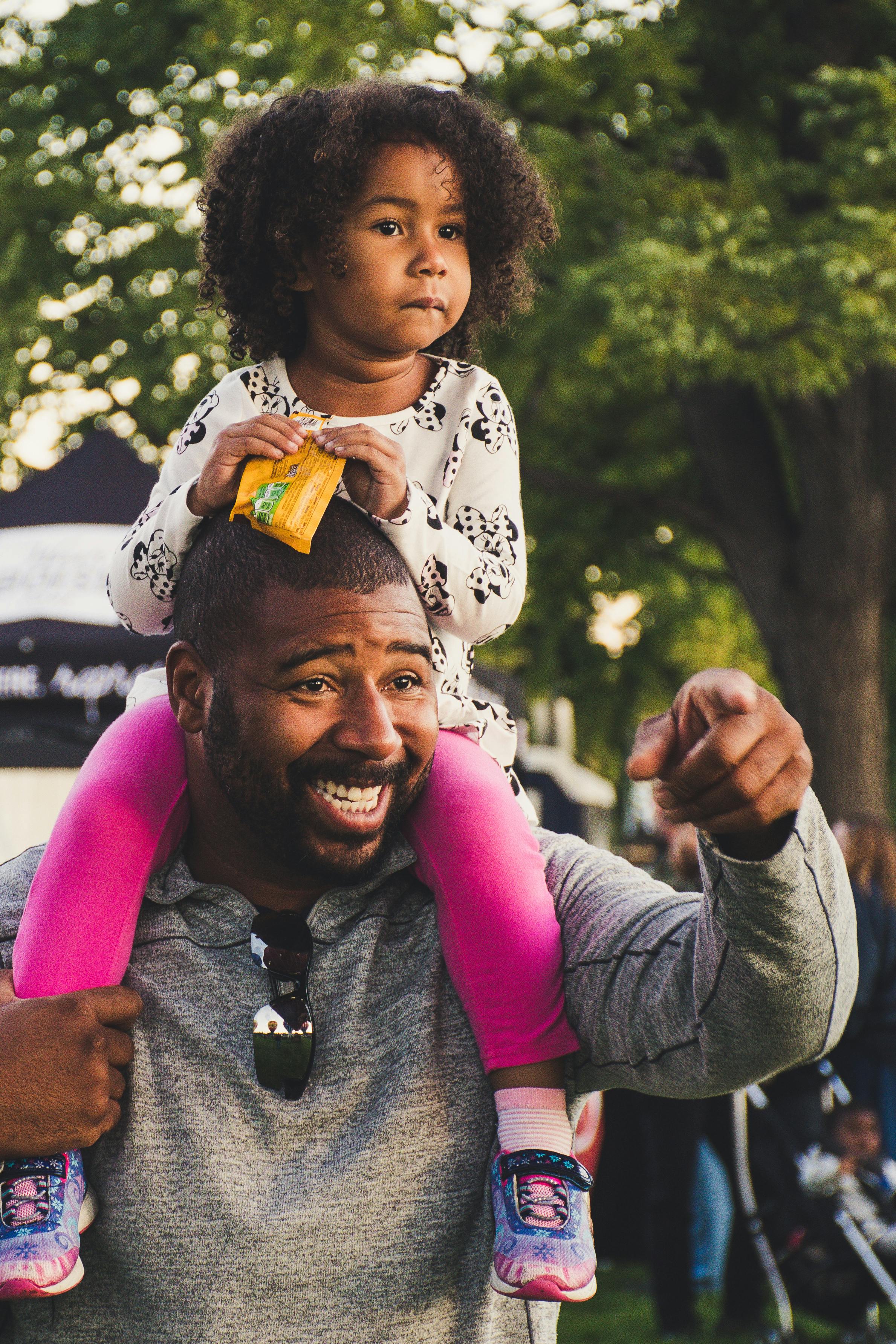 A man carrying his daughter on his neck