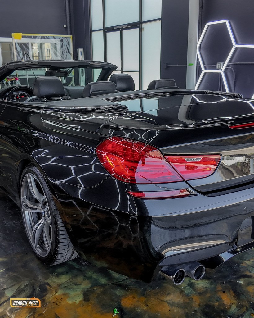 Hex shop lights reflected in the rear quarter of a black BMW M6 Convertible protected with Icon Rocklear, Dragon Auto Milpitas