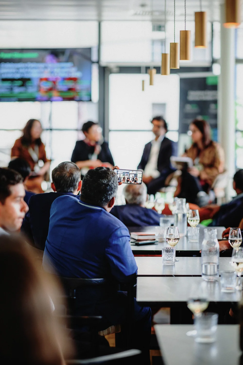Participant filmant les prises de parole lors de la table ronde