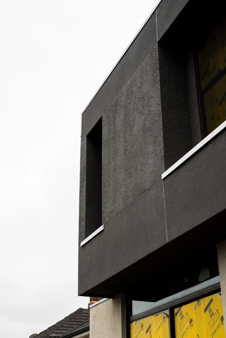 Modern architectural detail of a building with textured gray facade.