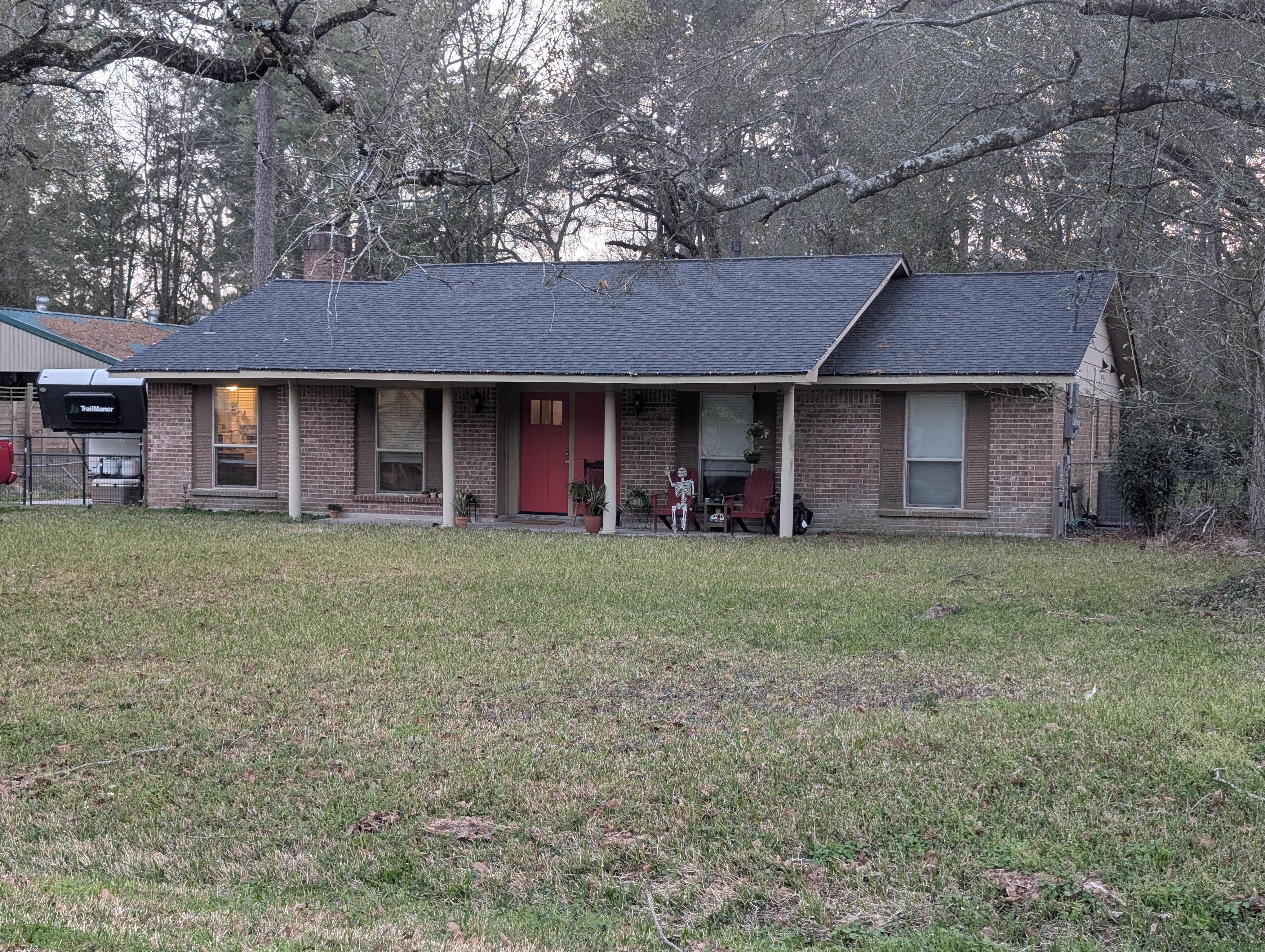 Brick house exterior before update — warm brown brick ranch with beige trim and white columns