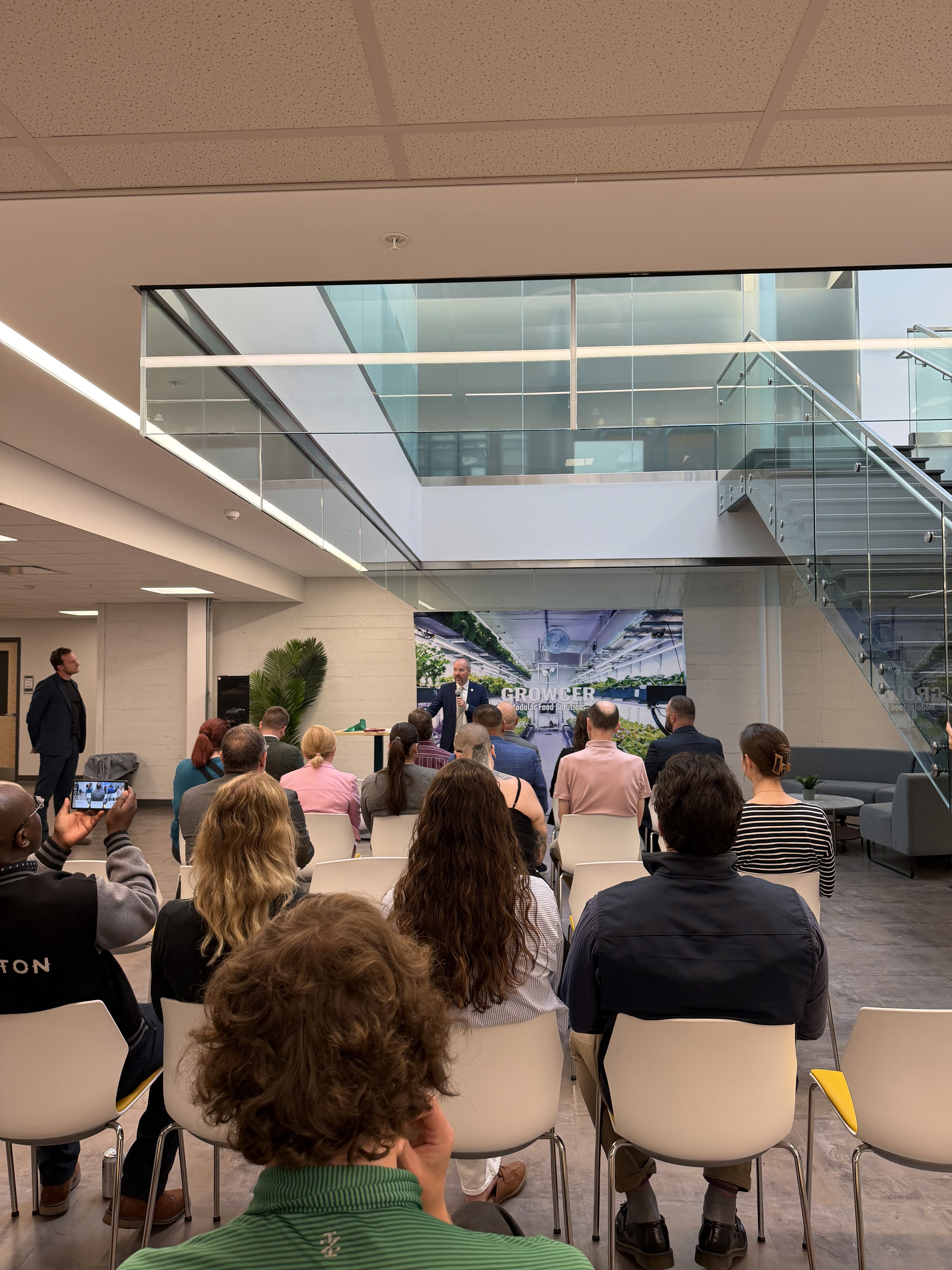 Group of professionals attending a presentation or networking event in a modern office space