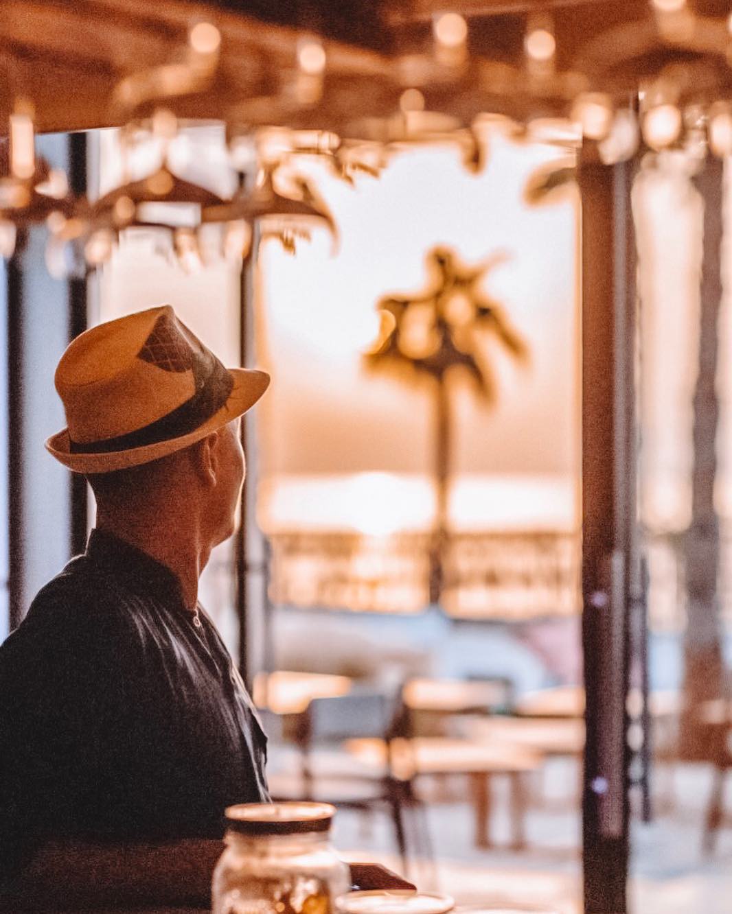 Black-and-white party photo of a smiling man in a check blazer among a crowd.