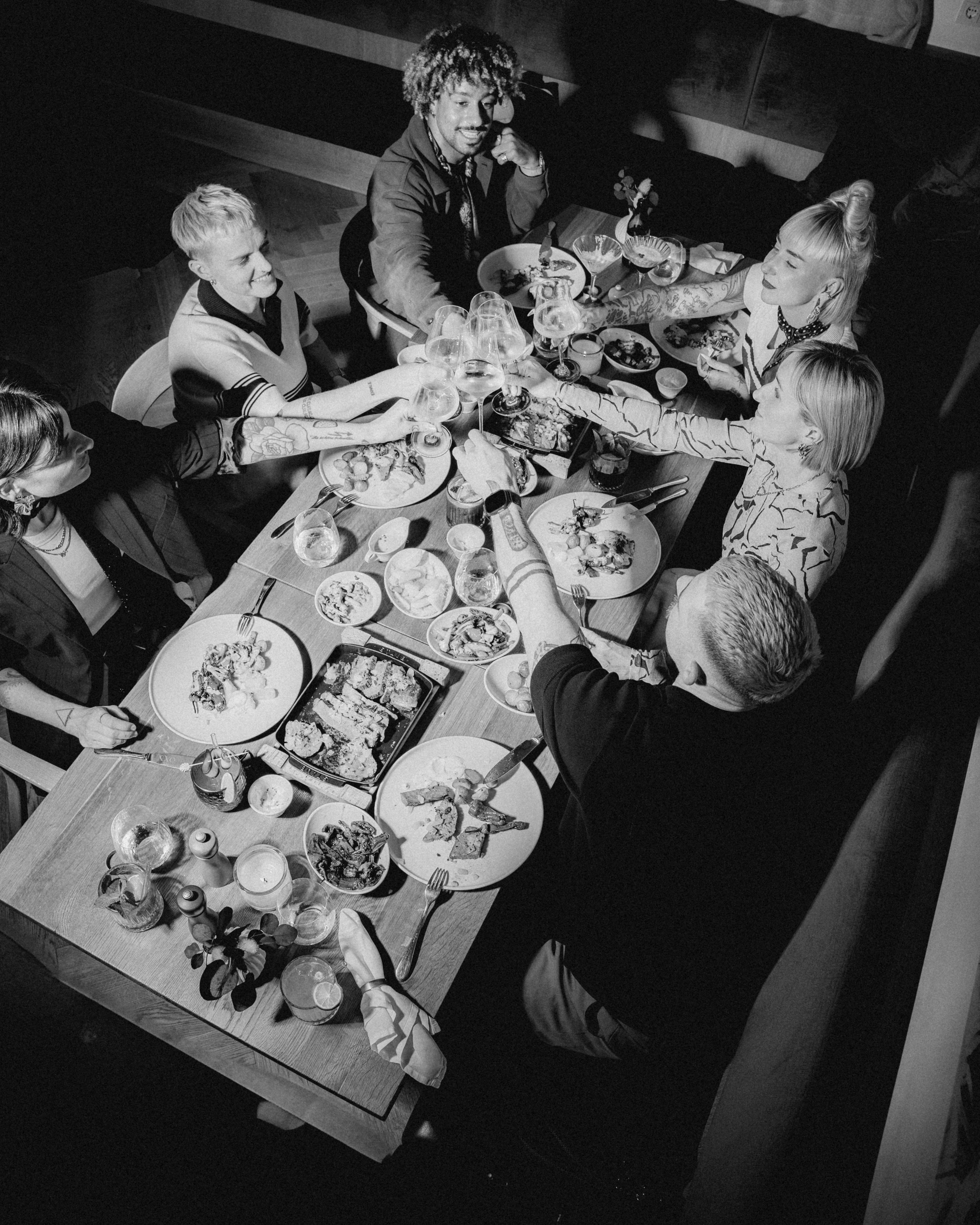A person walks through a narrow hallway lined with shelves, surrounded by framed photographs in black and white.