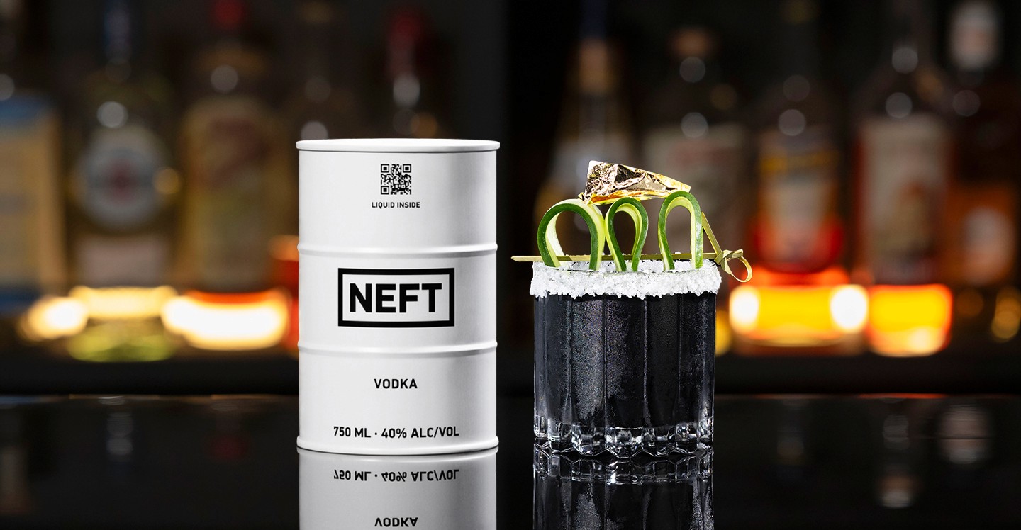 A NEFT Barrel and a glass of Black Gold on a bar counter.