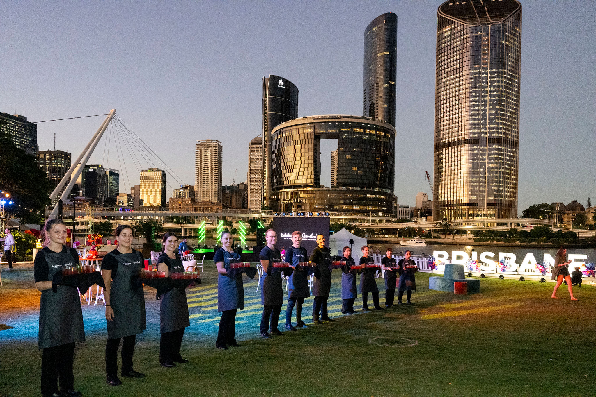 Staff lined up with trays of Arrival drinks on the Green at Southbank for the Australian Tourism Exchange