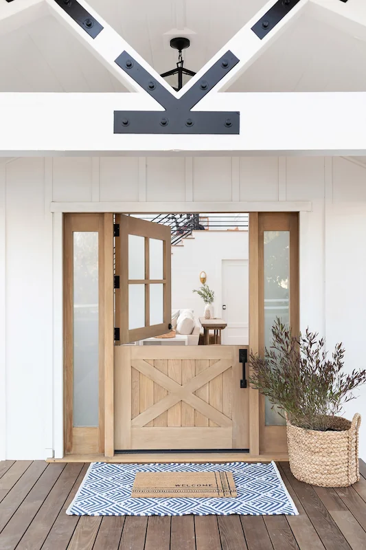 Wooden front door partially open, revealing a bright interior in North Tustin Remodel & Addition. Photo by Molly Rose.