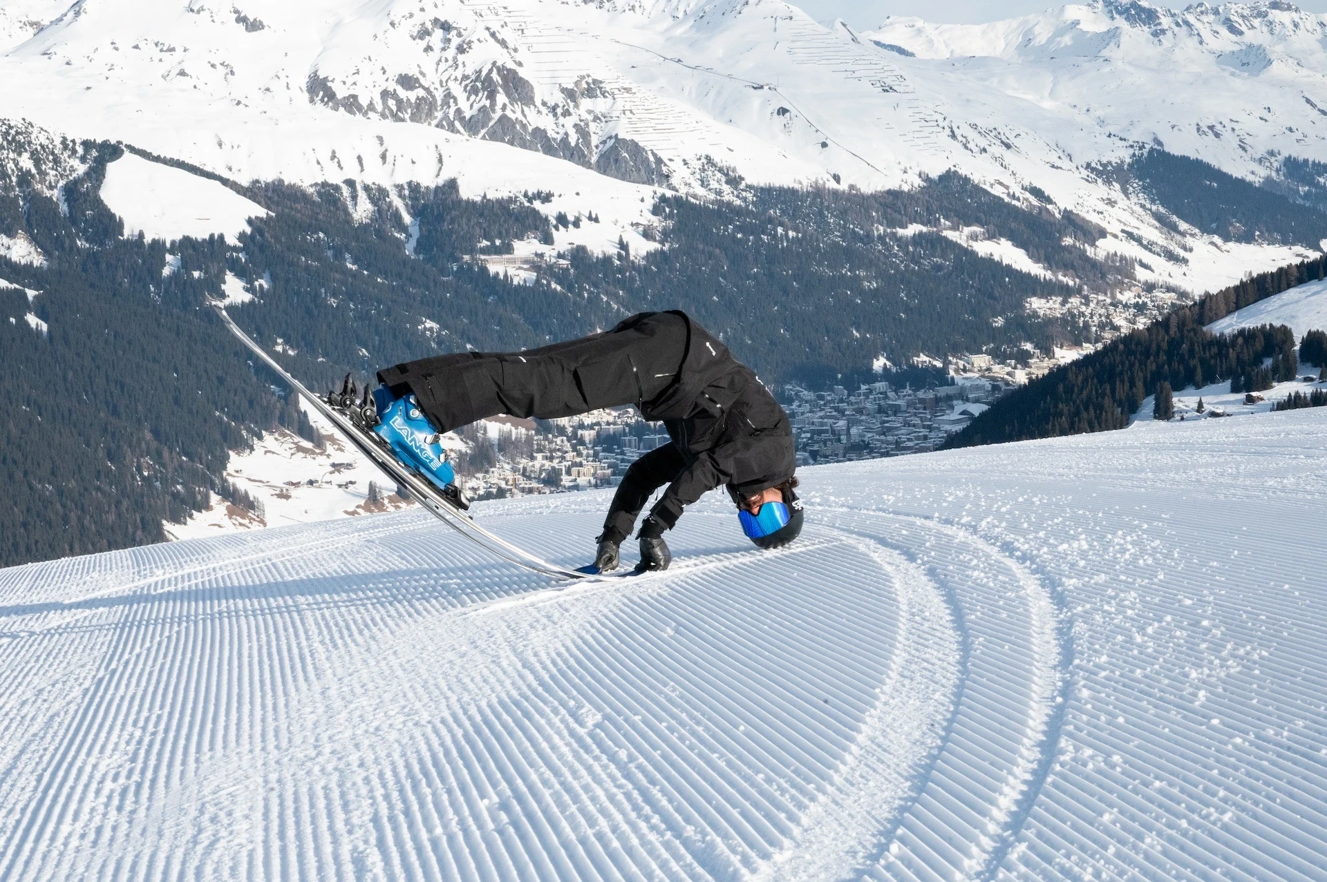 A skier standing on the tips of the skis with the head down.