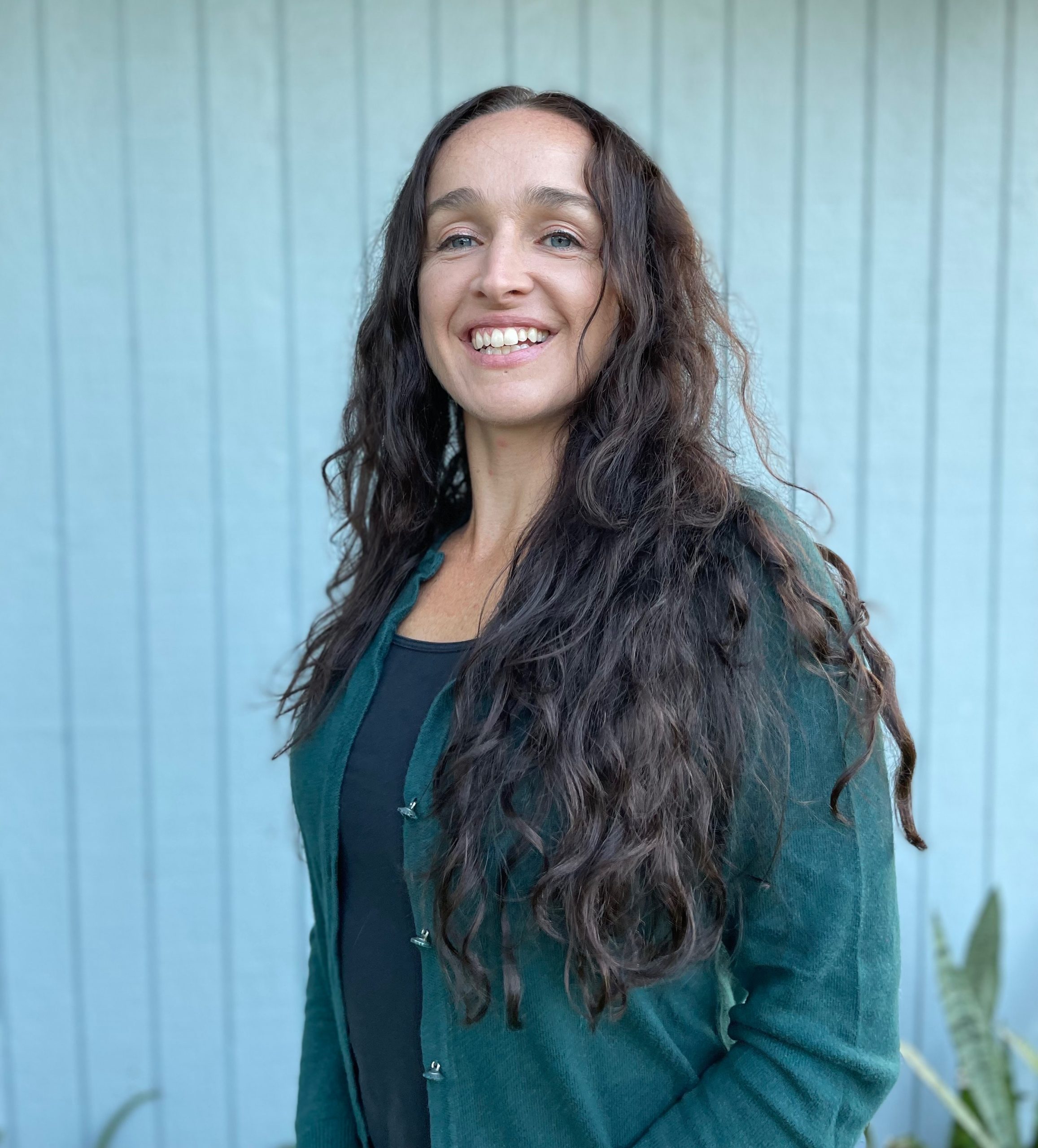 Portrait of a person in a pink sweater against a light background