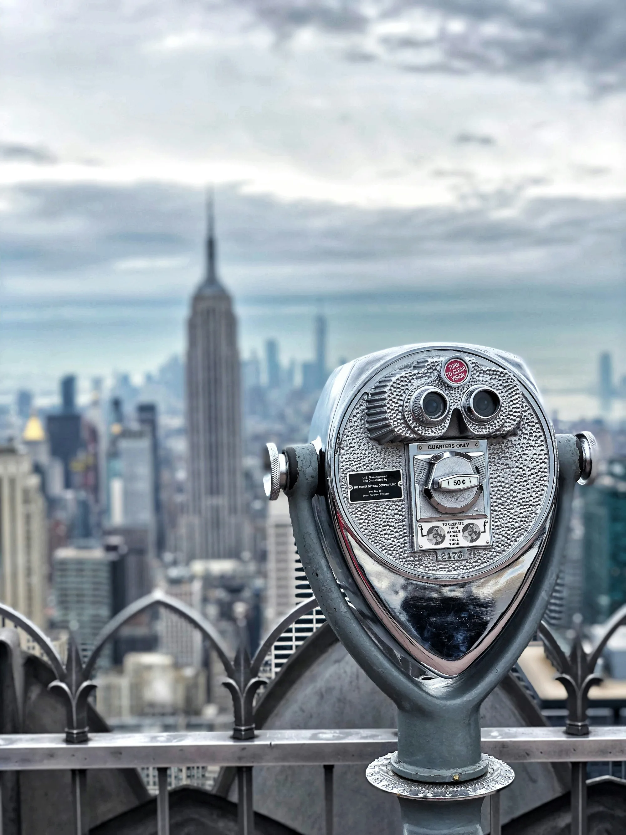 Observation binoculars at the top of Rockefeller Center, with the Empire State Building in the background.