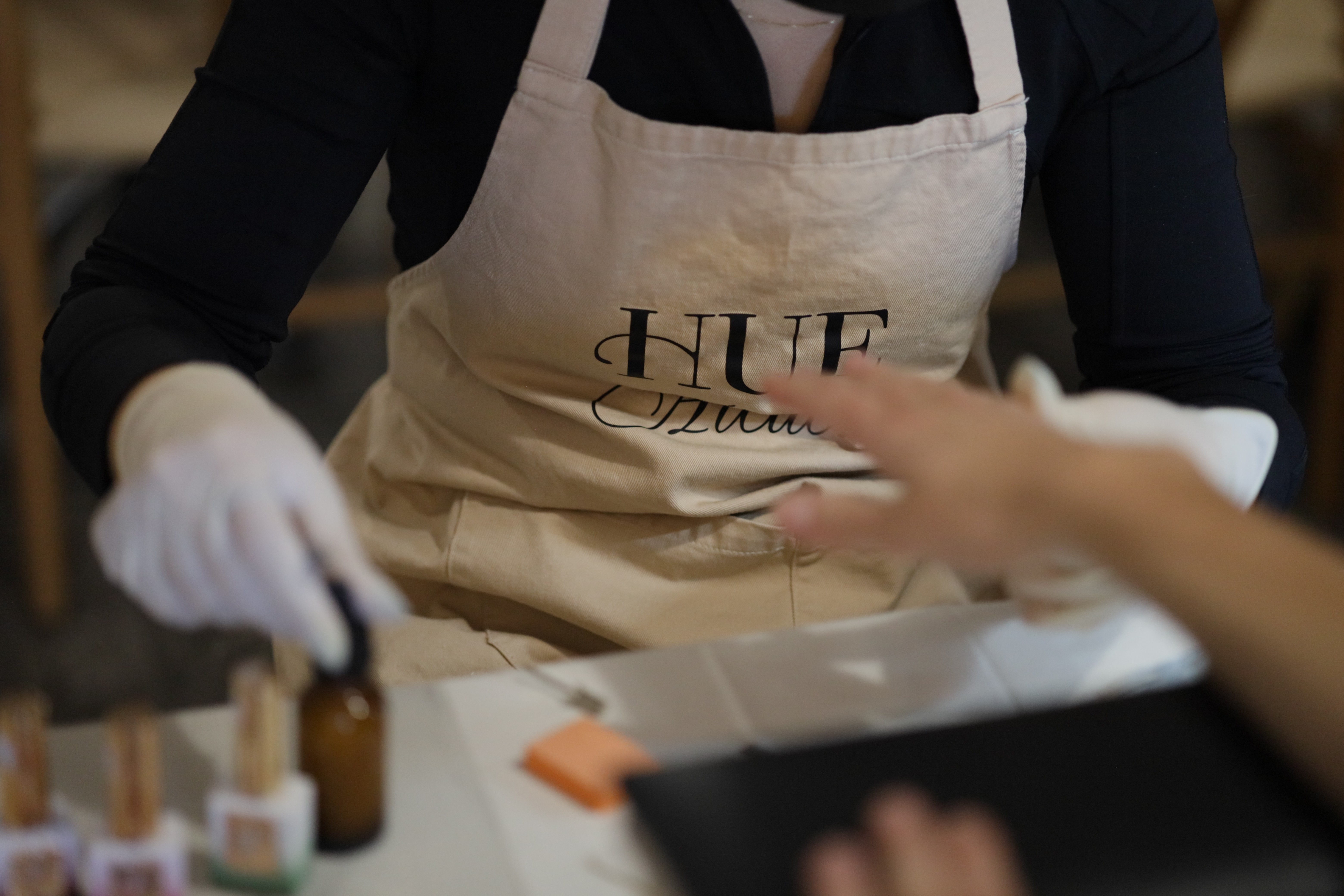 A woman lying on a massage bed, illuminated by soft sunlight streaming through a nearby window. A lush green plant in the background enhances the peaceful and rejuvenating ambiance.